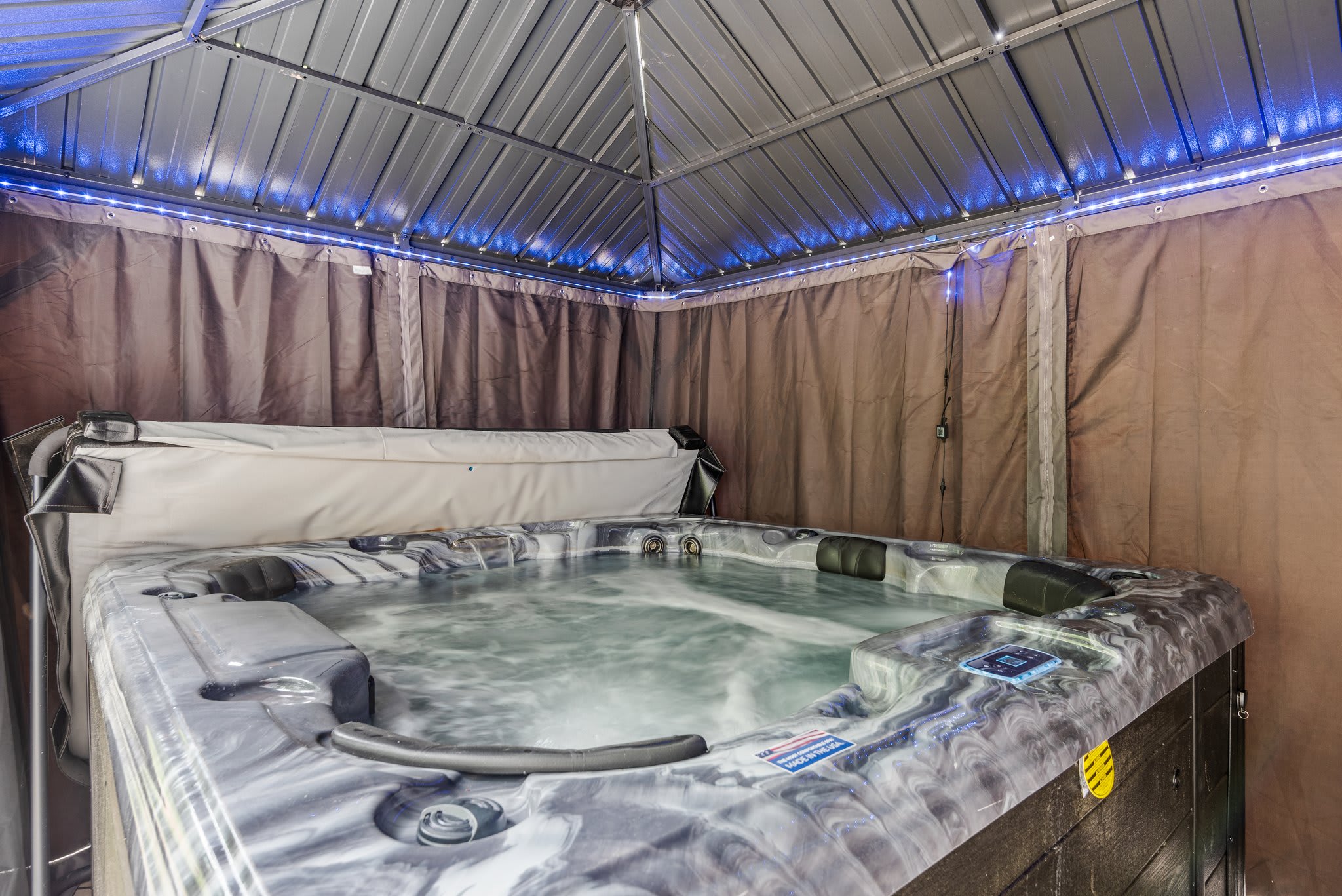 Tucked under a private canopy with ambient string lighting, the bubbling hot tub invites you to unwind no matter the season.