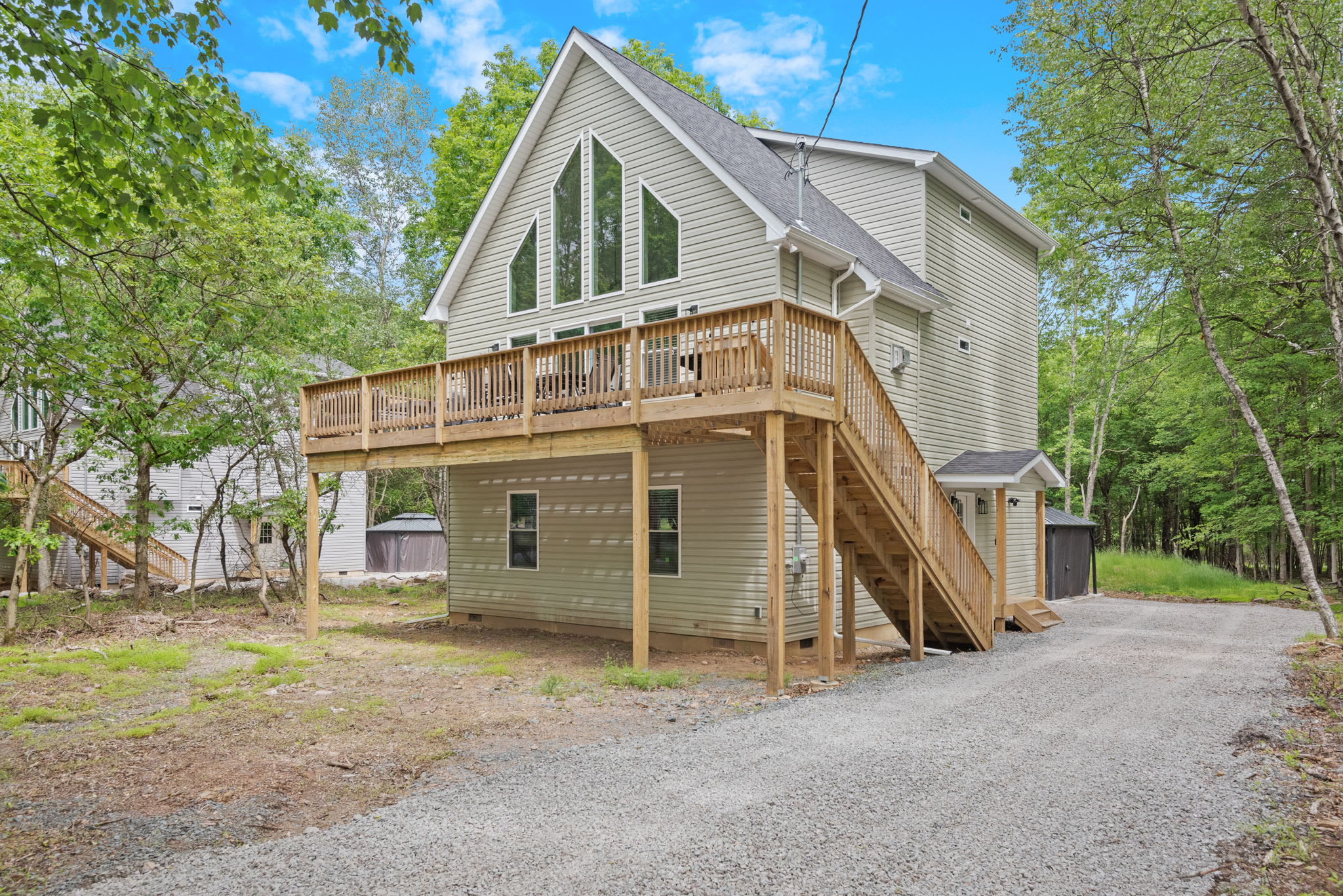 Daytime Exterior Front View
A full view of the home shows off the elevated deck, large windows, and tree-lined setting that makes this stay feel like a true escape.