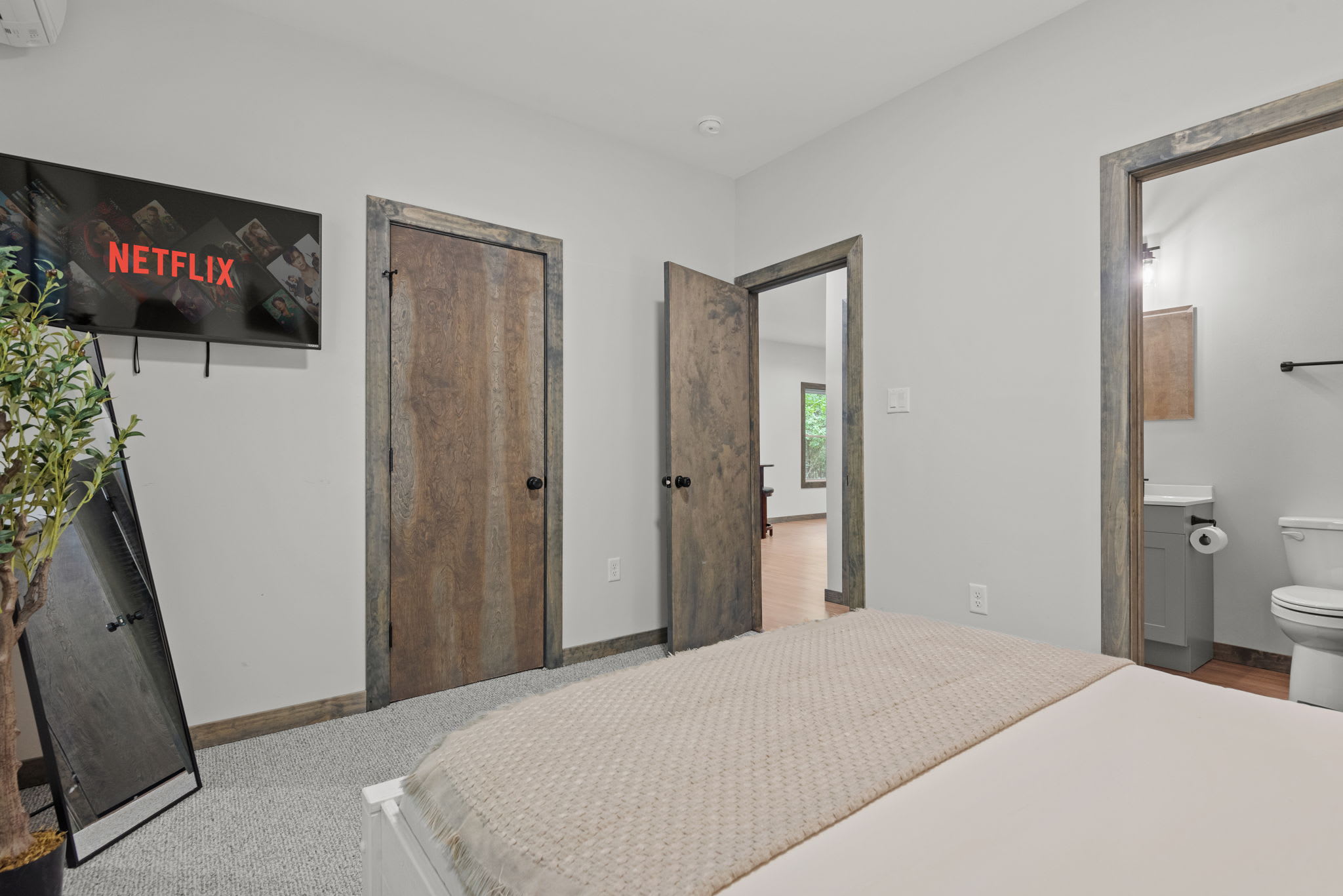TV, bathroom access, and warm wood tones make this bedroom feel like your own private retreat.