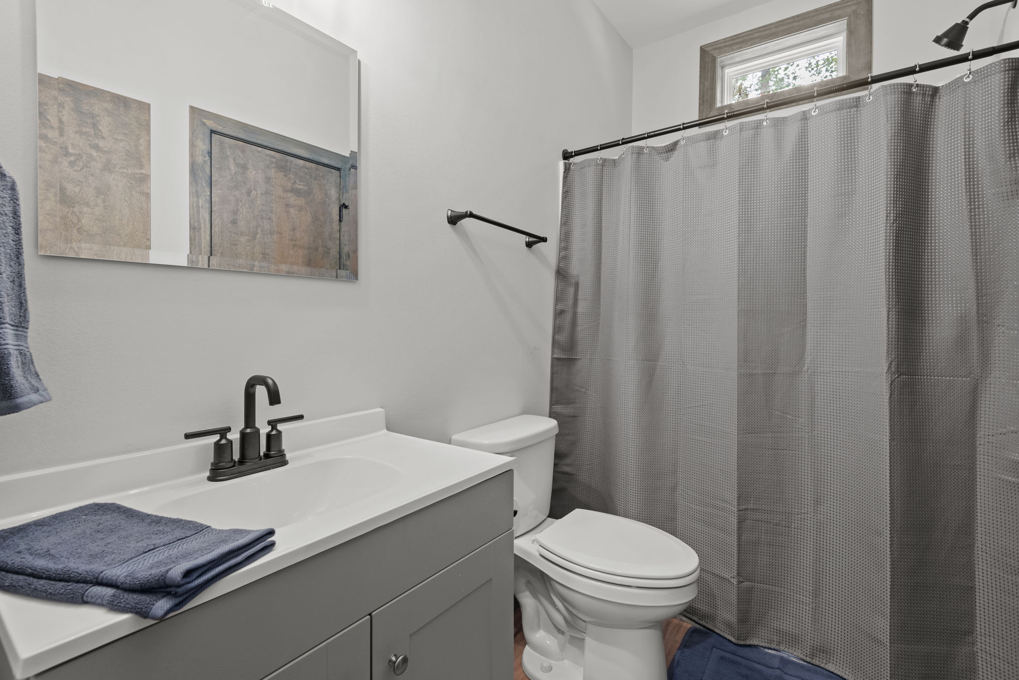 Bright and updated with a full tub, sleek vanity, and matte black fixtures. Functional and stylish for everyday comfort.