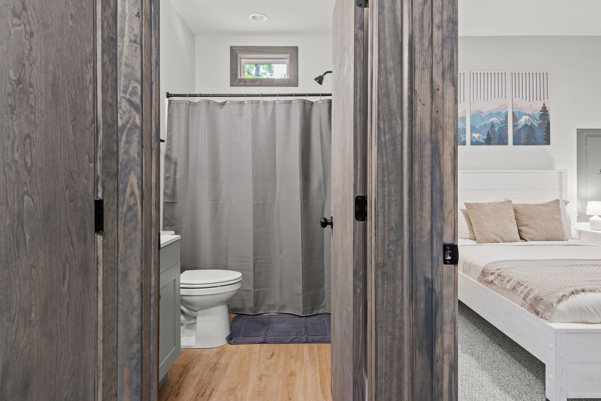 Double barn doors lead to a clean and bright full bathroom, completing the space with both privacy and style.