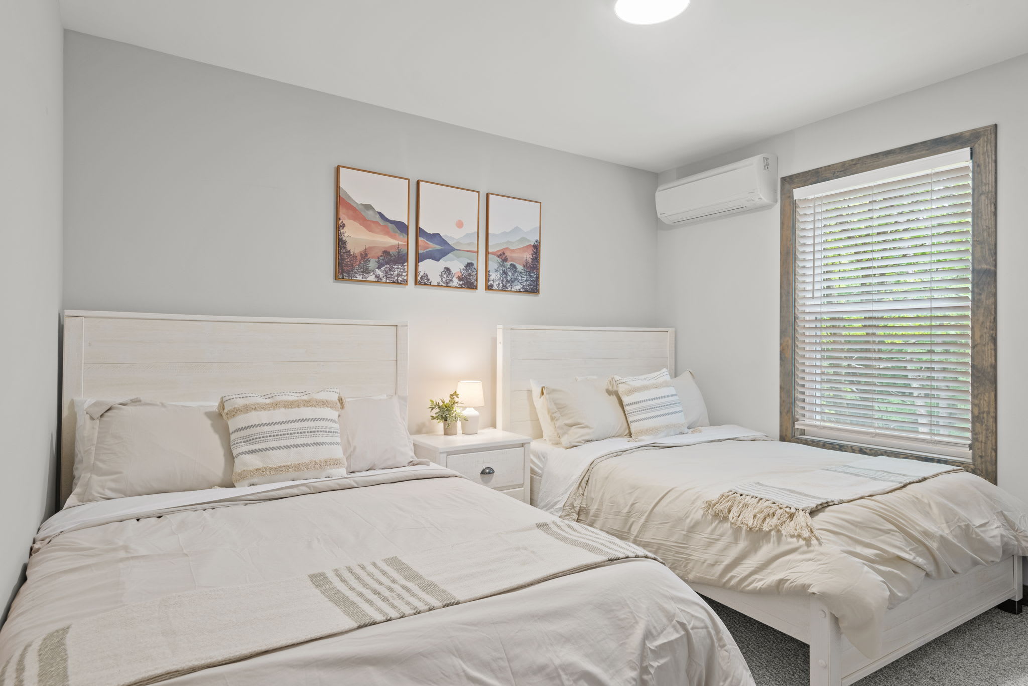 2 double beds with soft textures and warm lighting make this bedroom a great fit for both kids and adults.