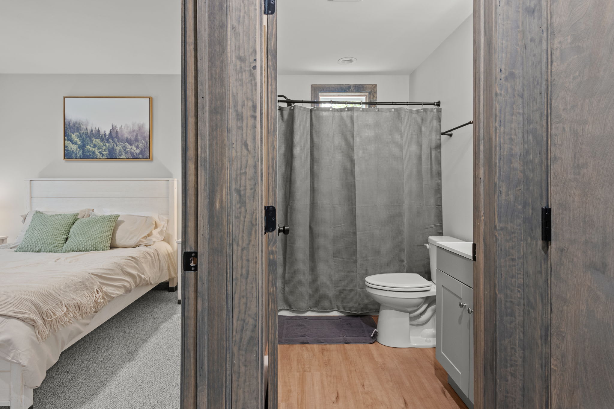 A seamless transition from sleep to shower. The rustic doors and clean finishes tie the whole look together.