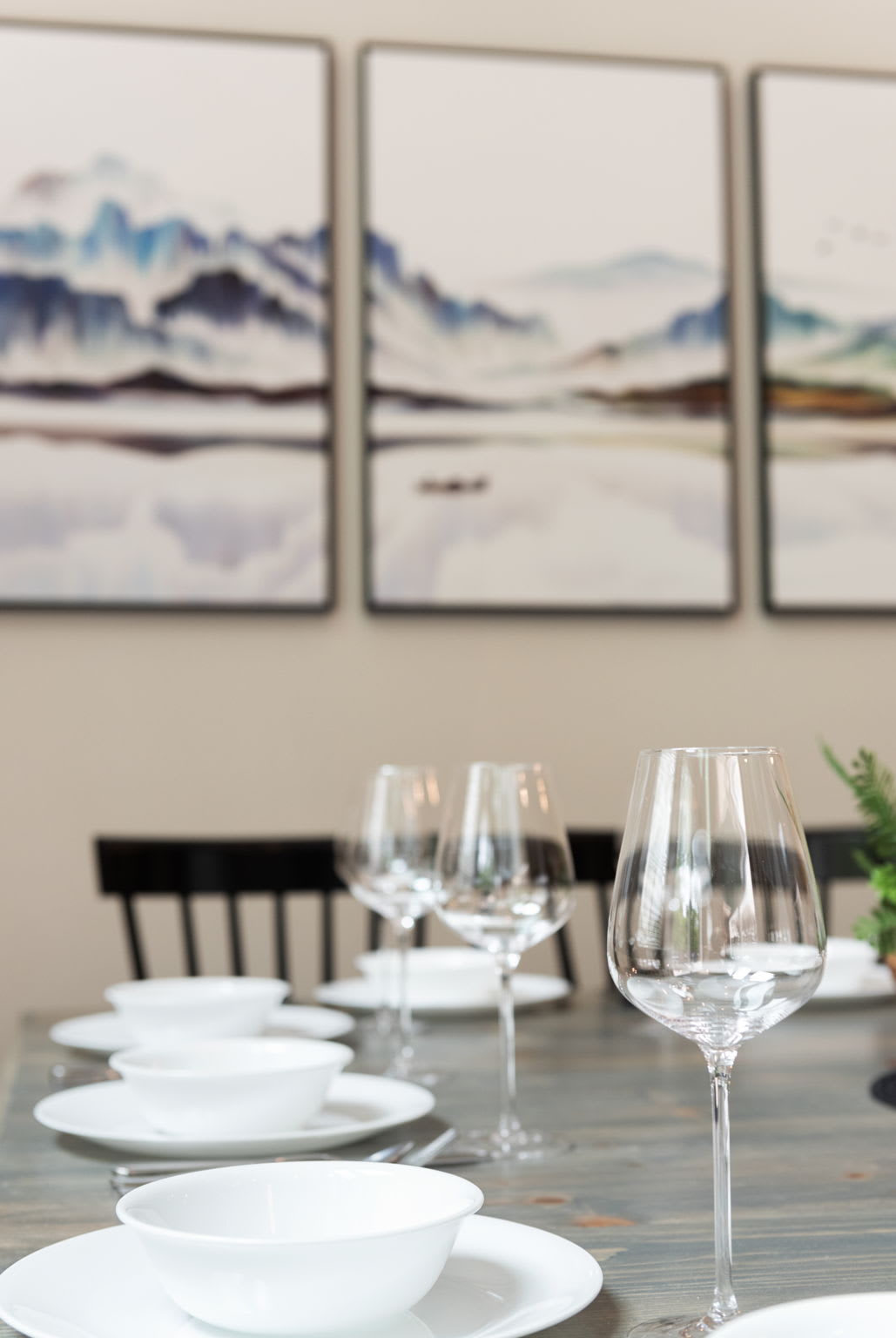 Soft tones and landscape art add a calming backdrop to the dining experience, tying into the home's peaceful aesthetic.