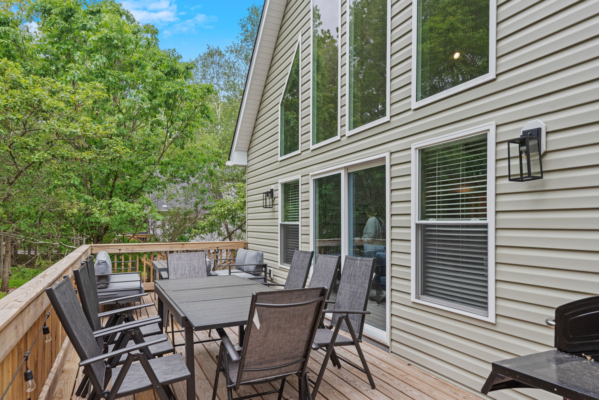 Deck Dining Setup
A spacious outdoor dining area with a grill, perfect for meals in the fresh air and surrounded by trees.