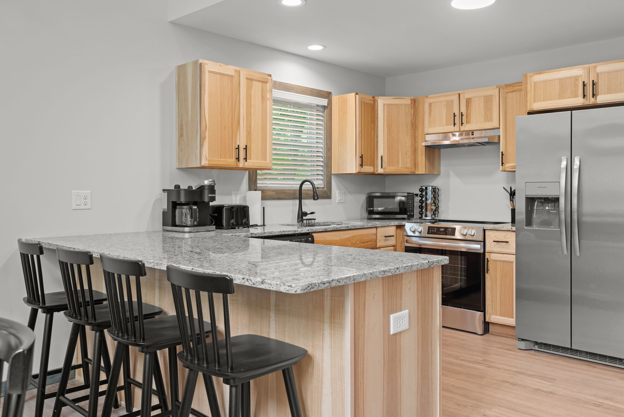 Kitchen with Island Seating
Bright and well-equipped with stainless steel appliances and an island with bar stools for casual dining or morning coffee.
