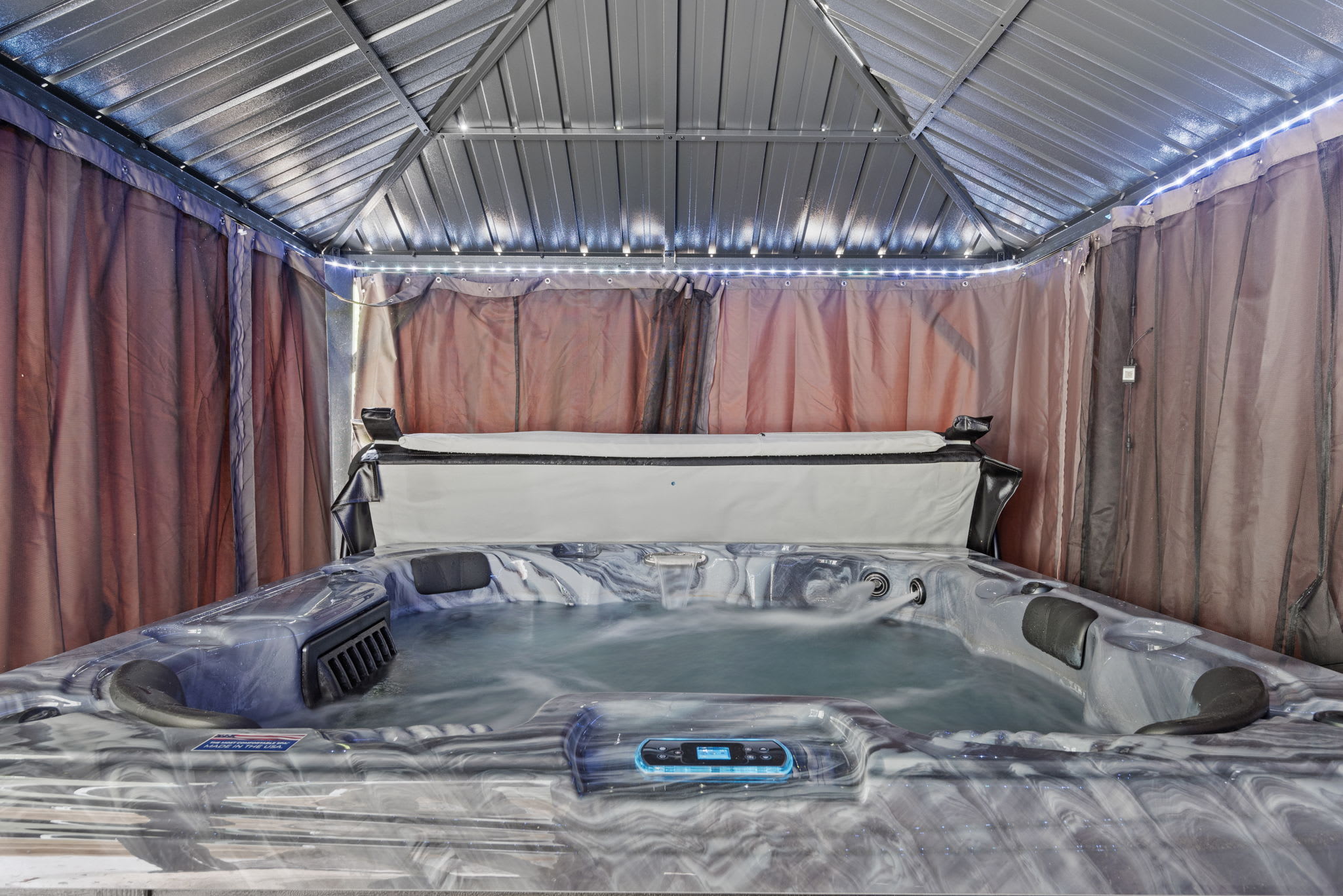The hot tub is tucked in a private, covered setup with soft lighting and plenty of space to stretch out and unwind.