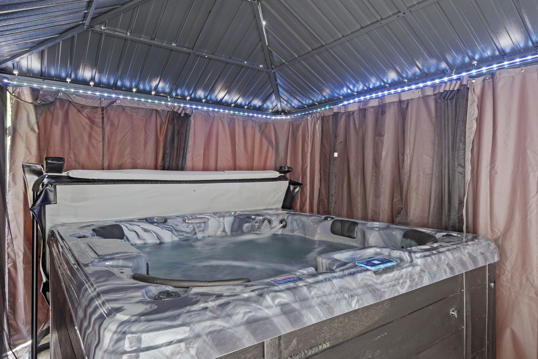 Relax fully in the covered hot tub space with curtain privacy, LED lighting, and a perfect soak after a day out.