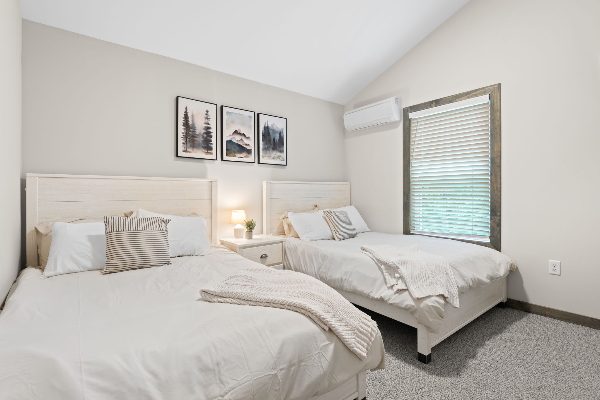 2 double beds with soft textures and gentle lighting make this upstairs bedroom a peaceful spot for kids or guests.