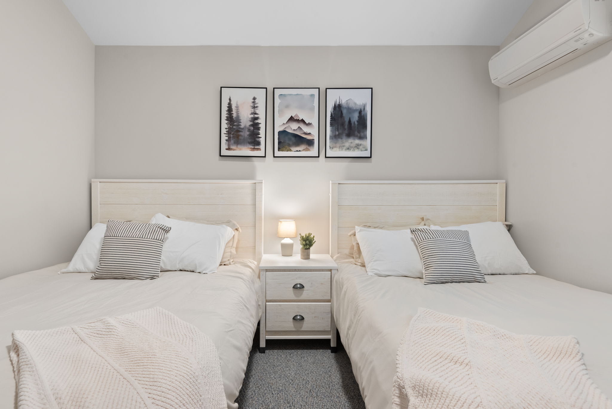 Balanced and cozy with wall art and bedside storage, this twin setup is ideal for groups or siblings.