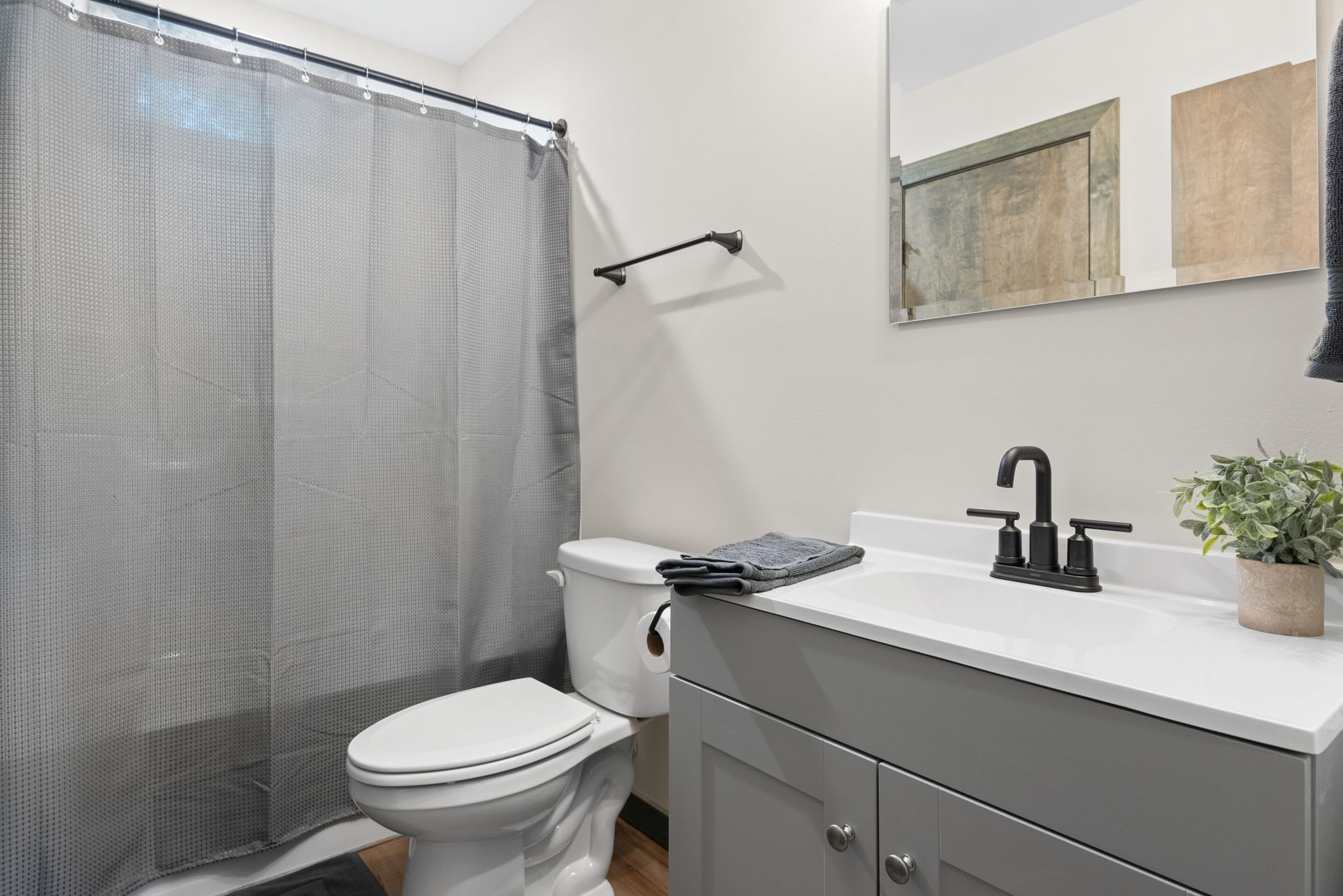 A fresh and modern bathroom featuring a full tub, dark fixtures, and clean lines with plenty of counter space.
