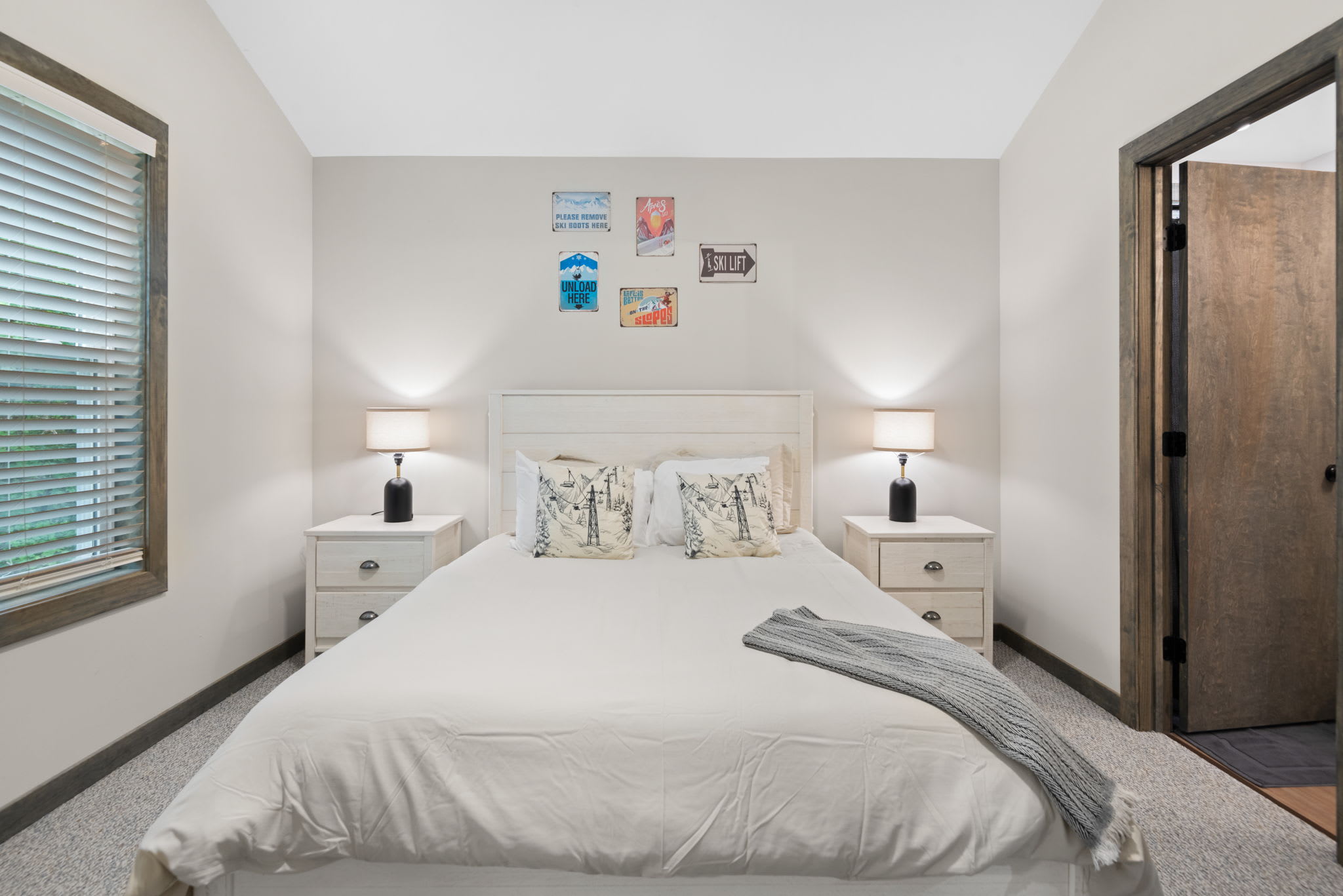 Simple and serene with twin nightstands, matching lamps, and wall art for a laid-back and inviting sleep space.