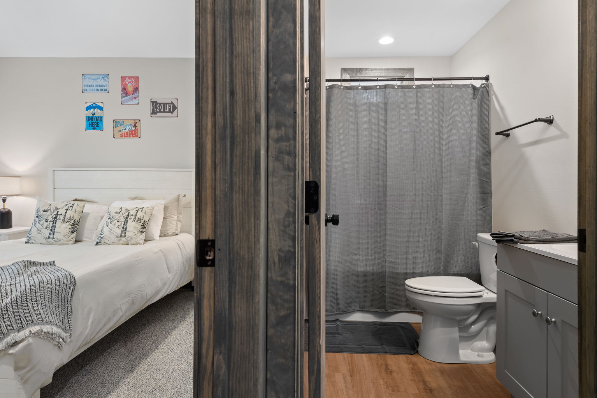 Clean and private with rustic doors and modern finishes, this full bathroom completes the suite with ease and style.