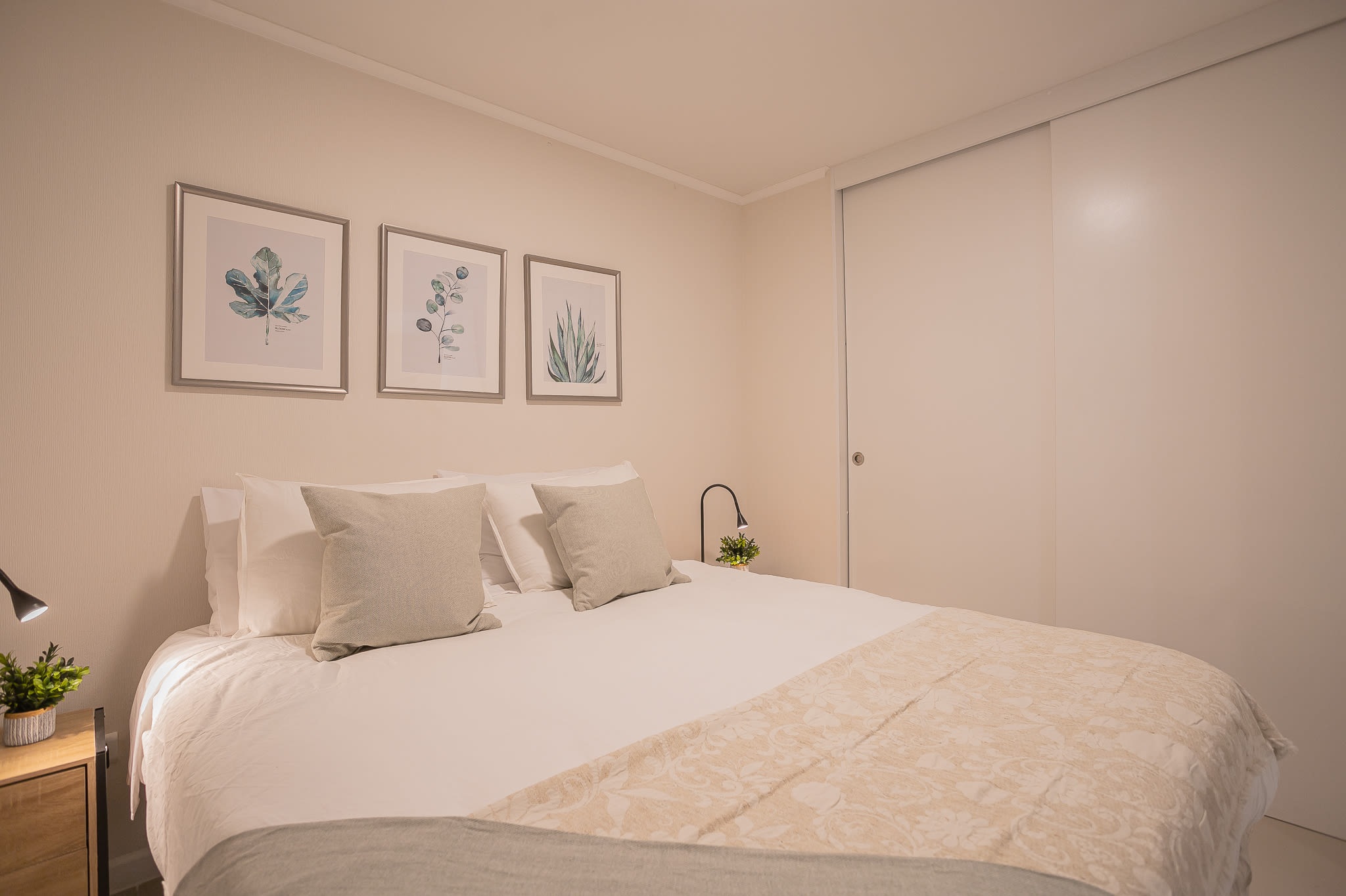 Relax in this cozy bedroom with elegant decor and calming botanical prints, perfect for unwinding after a day of exploring.