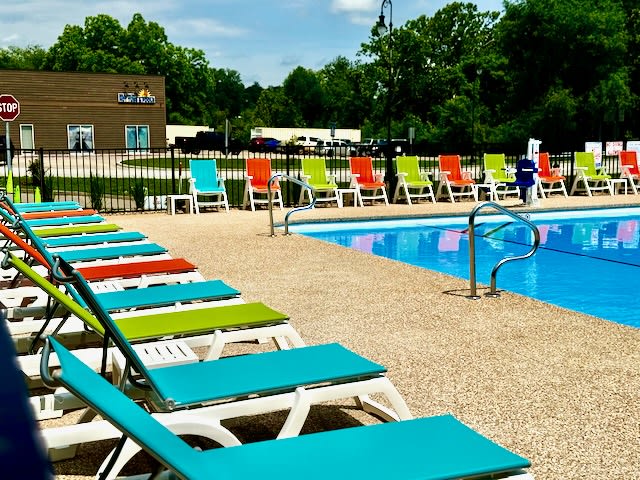 One of the nicest pools in Branson with deck chairs and tables