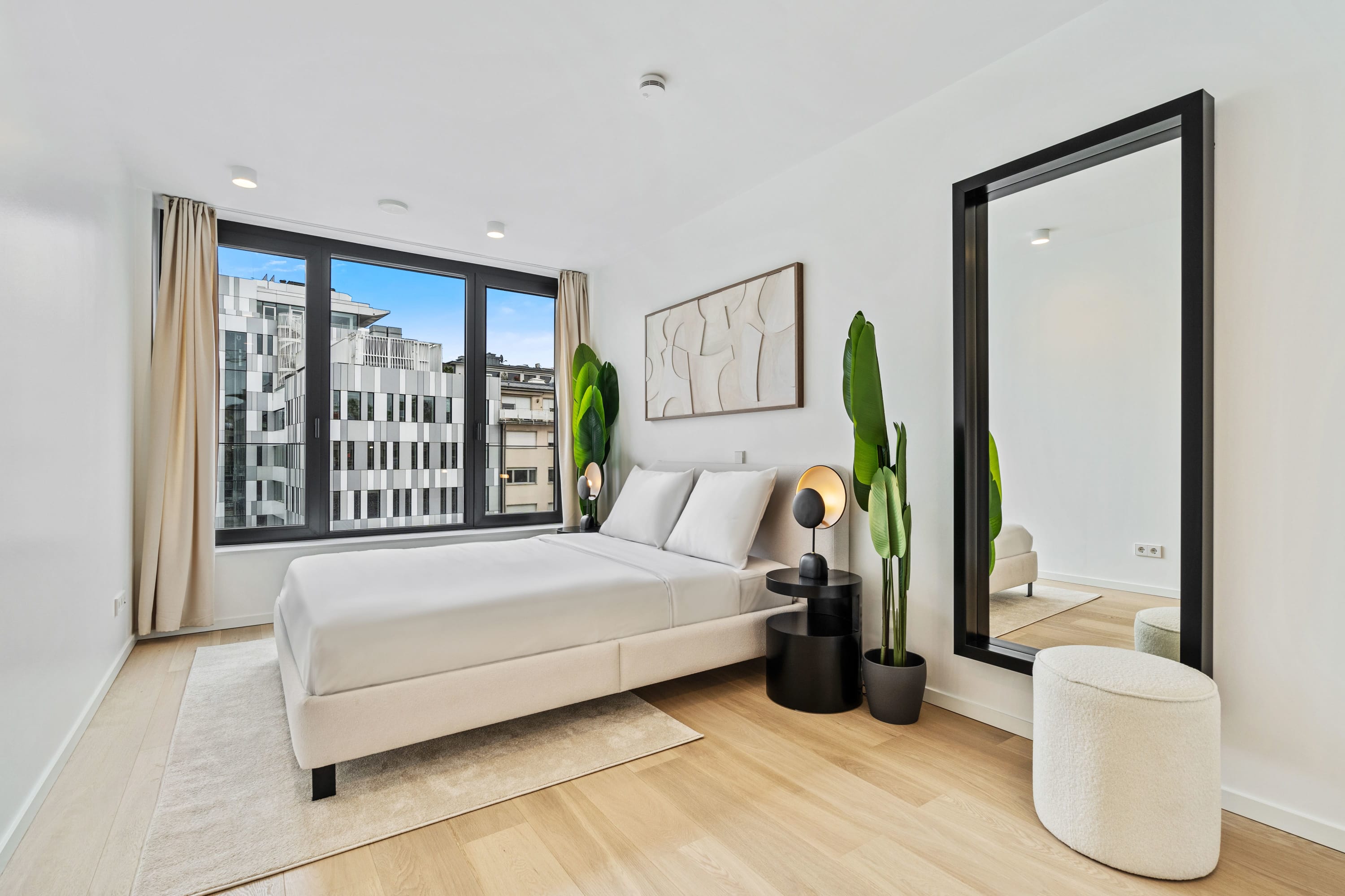 Elegance and ease go hand-in-hand in this bedroom with captivating urban vistas.