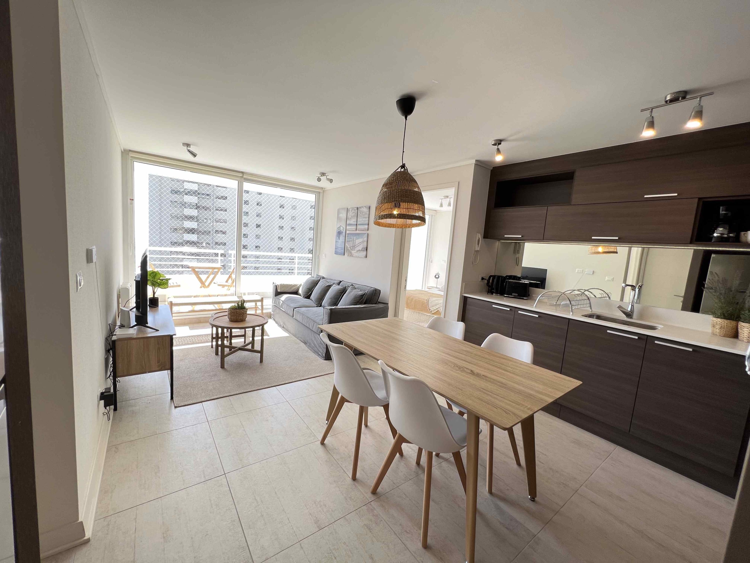 Bright and modern living area with integrated kitchen and balcony access, perfect for relaxation and dining.