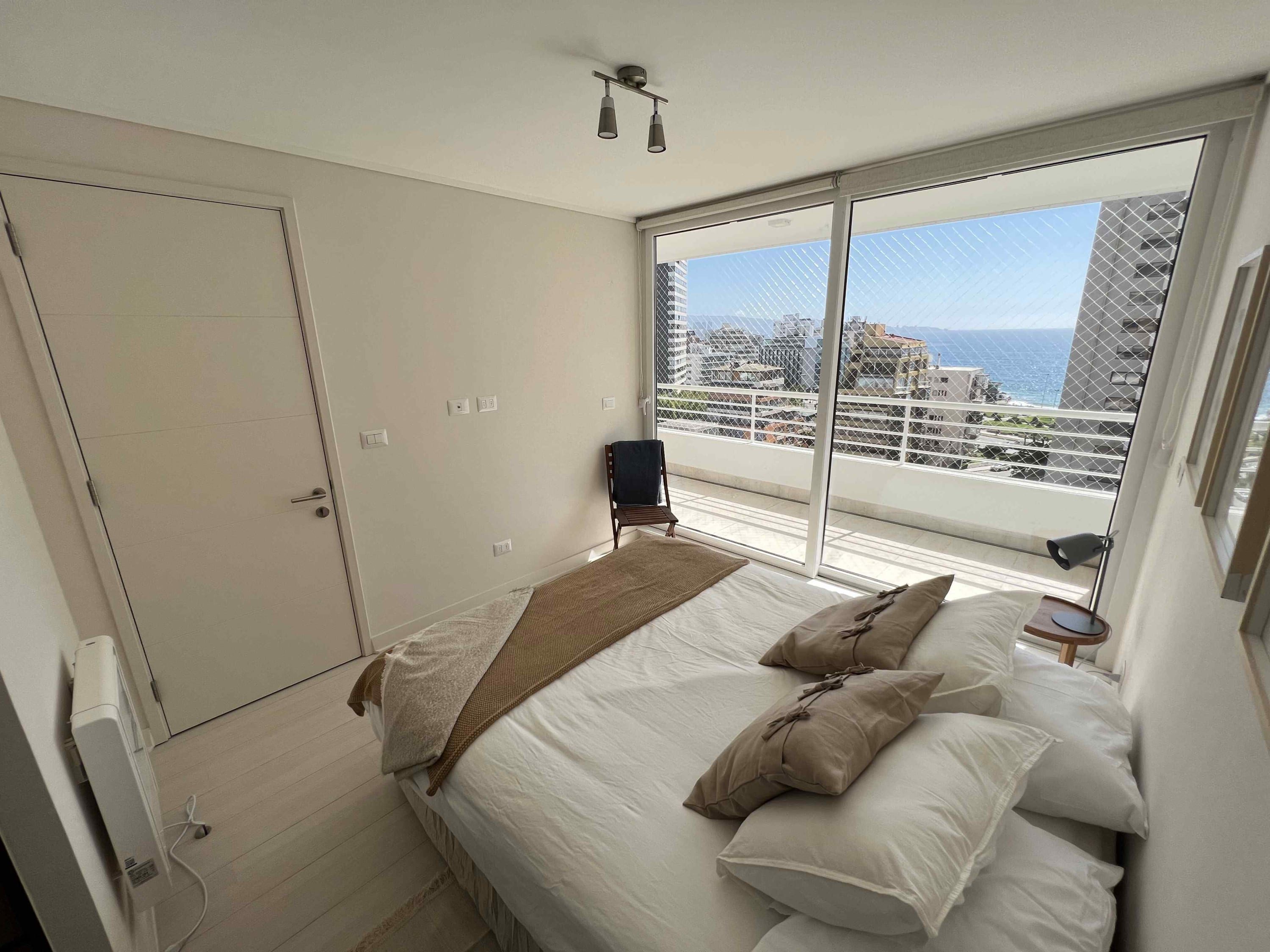 Relax in a bright, cozy bedroom with stunning ocean views from your private balcony.