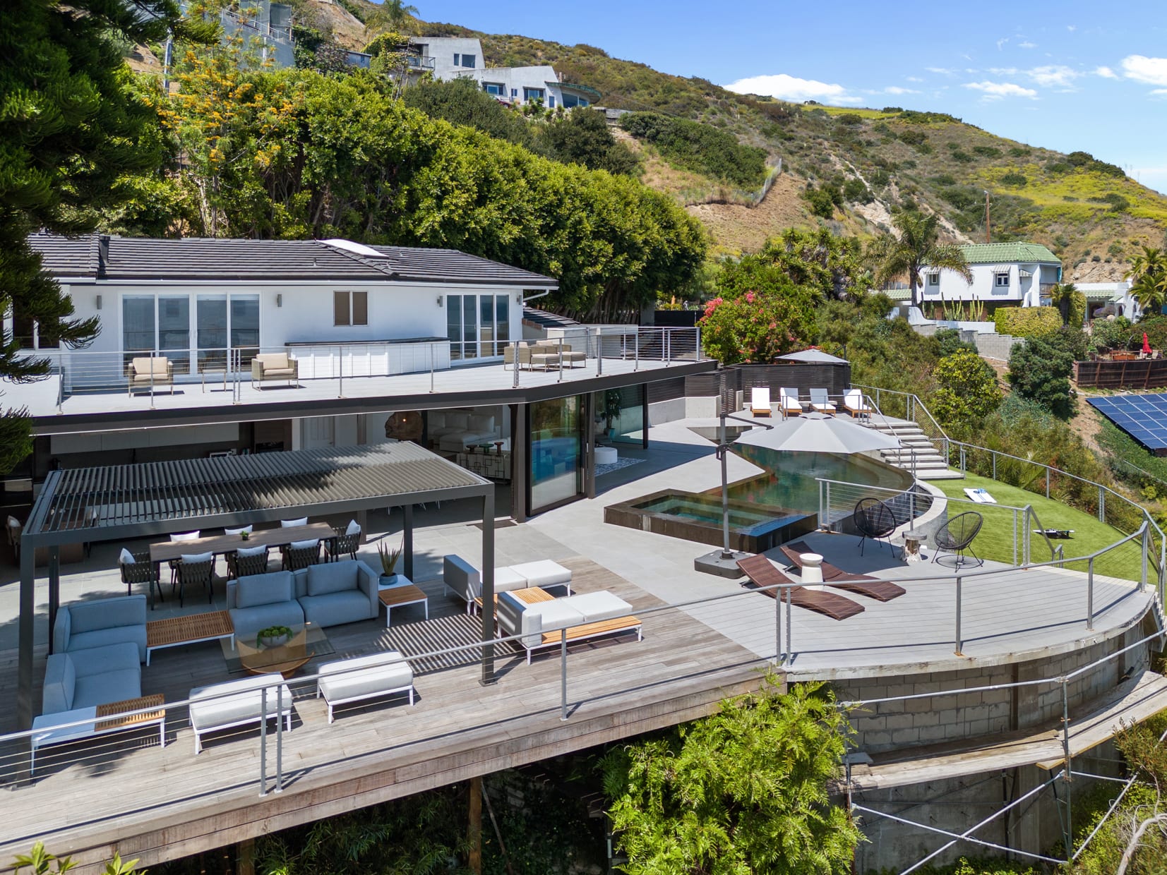 The outdoor area is a serene retreat, featuring expansive spaces for lounging, dining, and enjoying the view.
