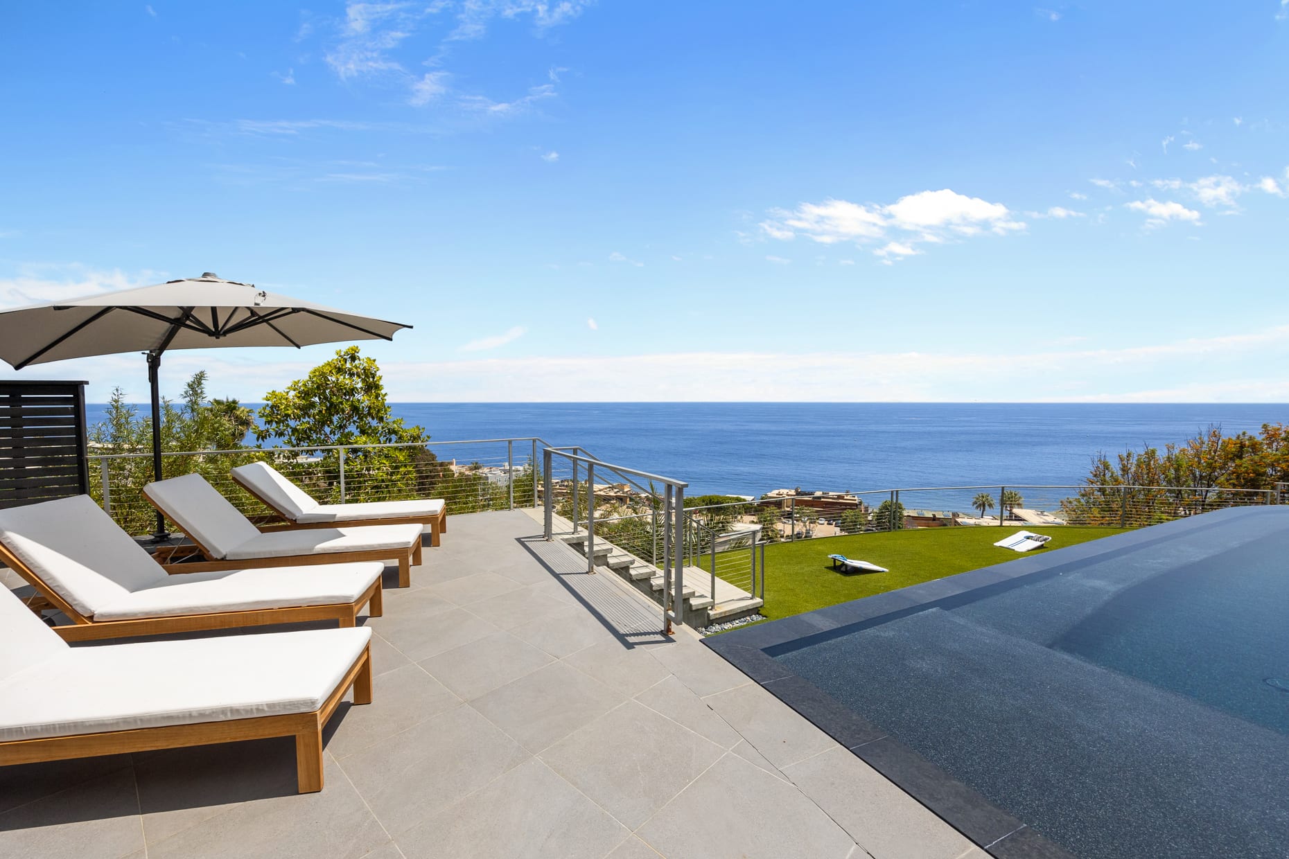 Sunbathe in style on luxurious sunbeds overlooking the infinity-edge pool and the Pacific Ocean beyond.