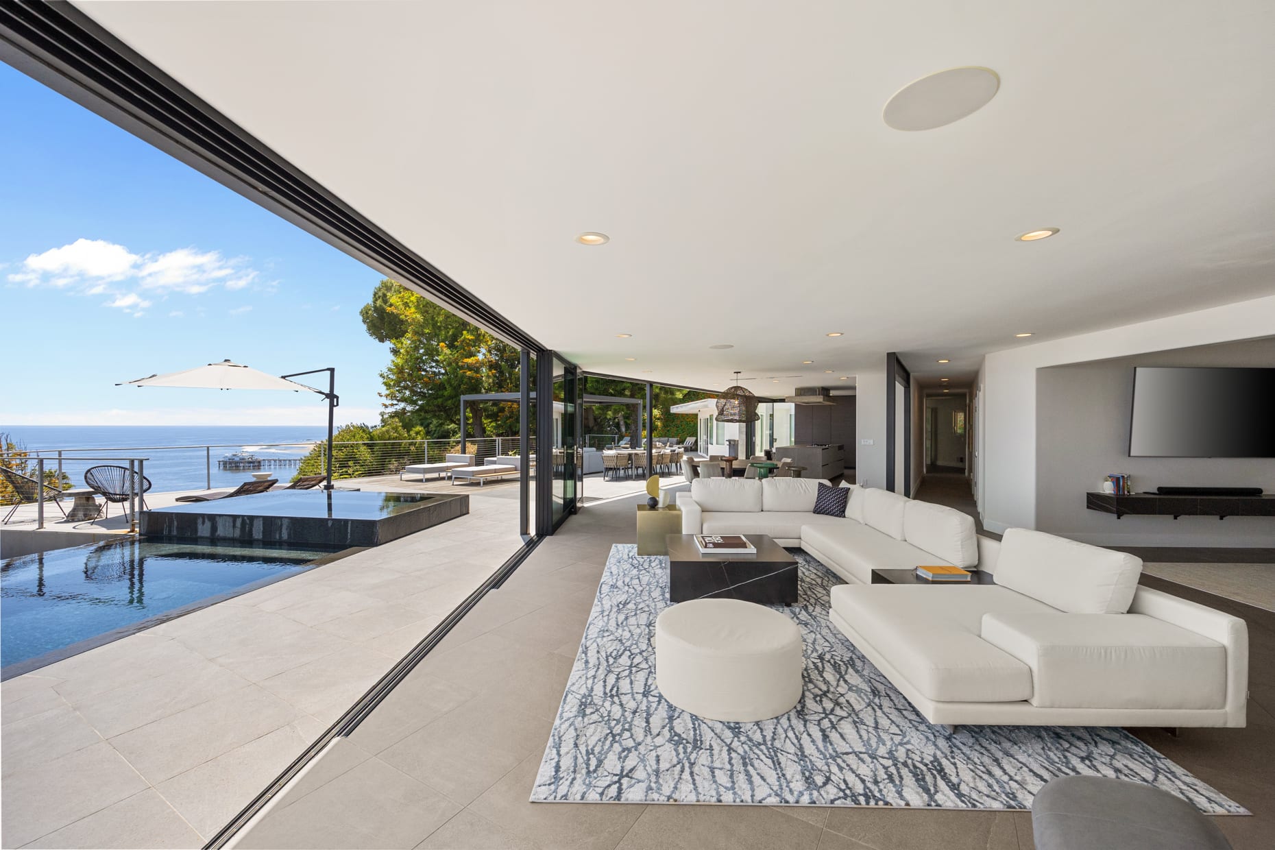 The living room is designed for relaxation and entertainment against a backdrop of endless sea.