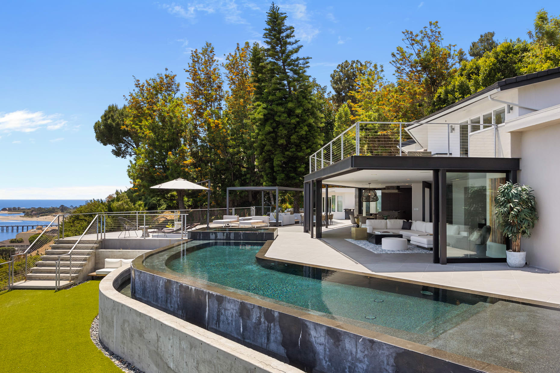 The living room seamlessly transitions to the poolside, offering direct access and stunning views.