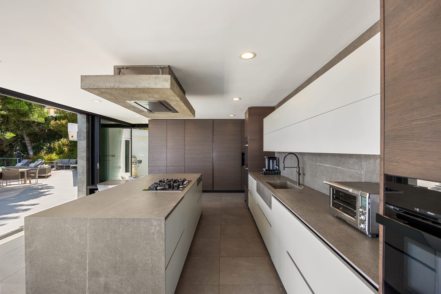 Sleek countertops and modern cabinetry offer ample storage and workspace, perfect for gourmet cooking.
