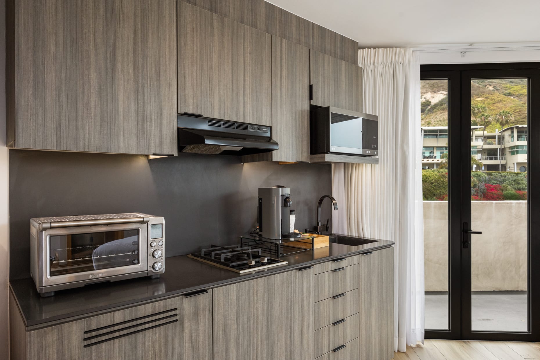 - Enjoy a well-equipped kitchenette boasting top-of-the-line appliances and a convenient coffee machine stocked with pods for your enjoyment.