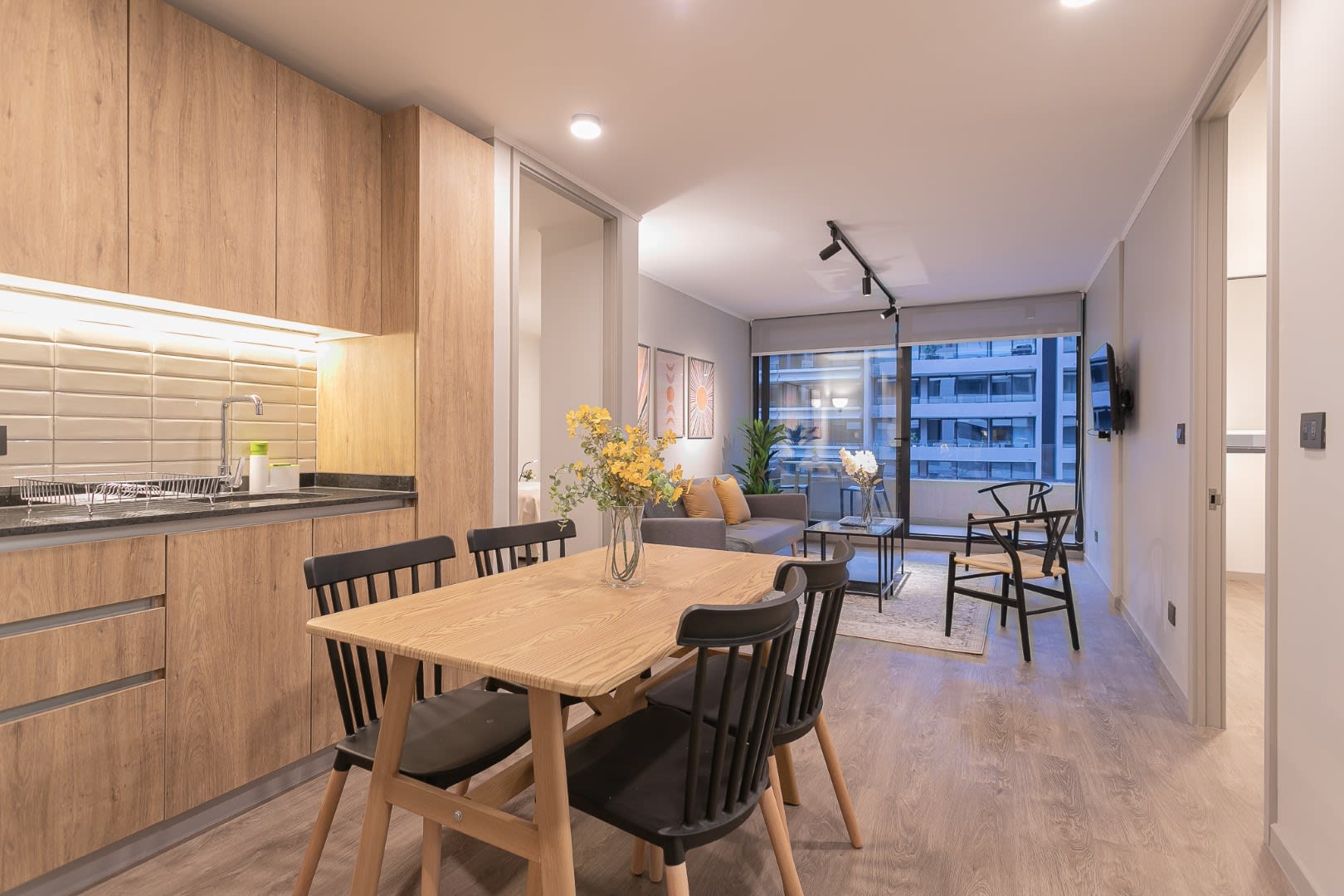 Stylish open-plan dining and living area with modern decor and large windows for a bright, inviting atmosphere.