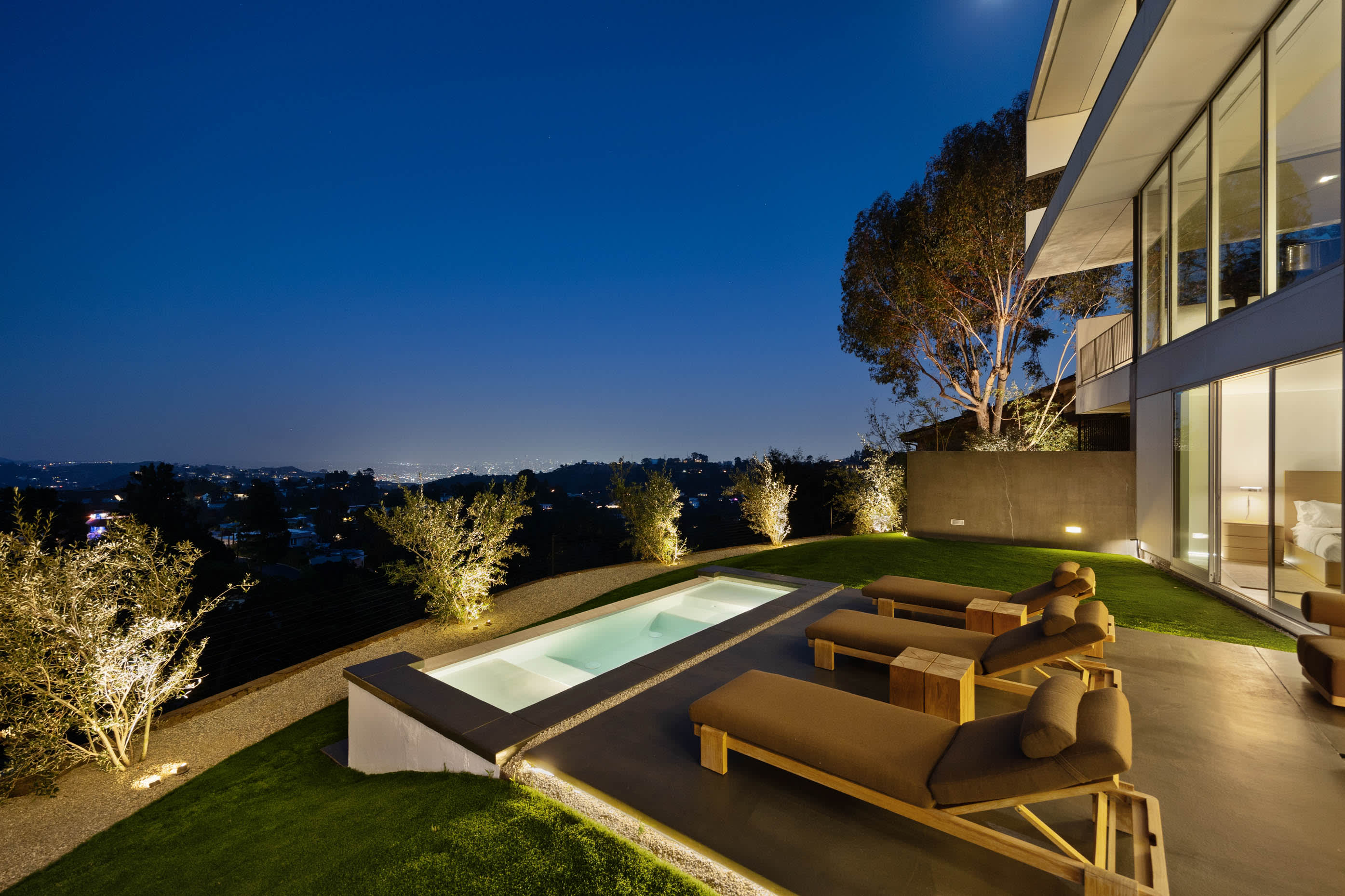 Relax in style with RH Modern furniture and sun loungers by the pool.