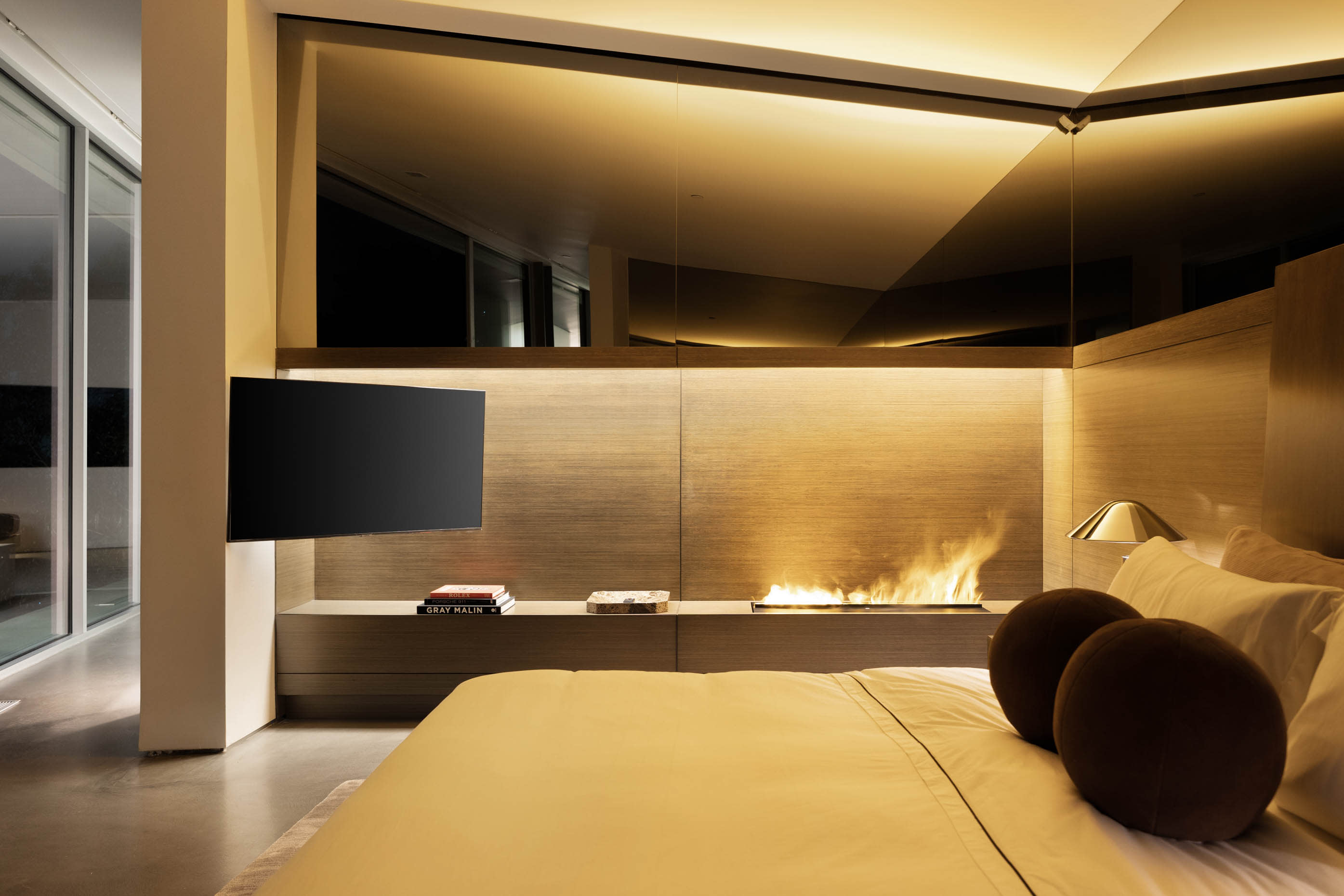 Bedroom featuring an avant-garde fireplace that exudes contemporary sophistication.