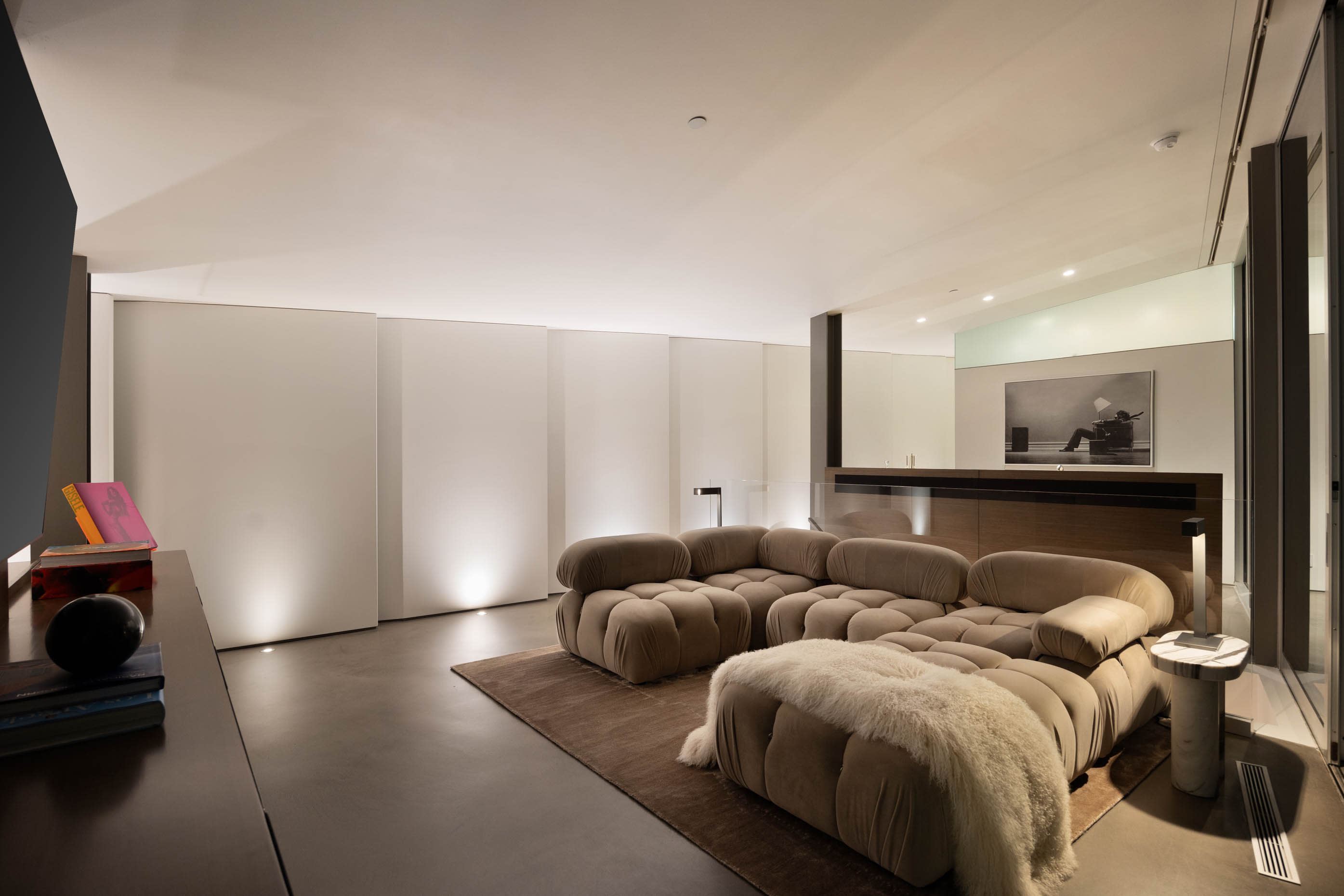 Indulge in comfort with a plush Camaleonda sofa facing a sleek TV.
