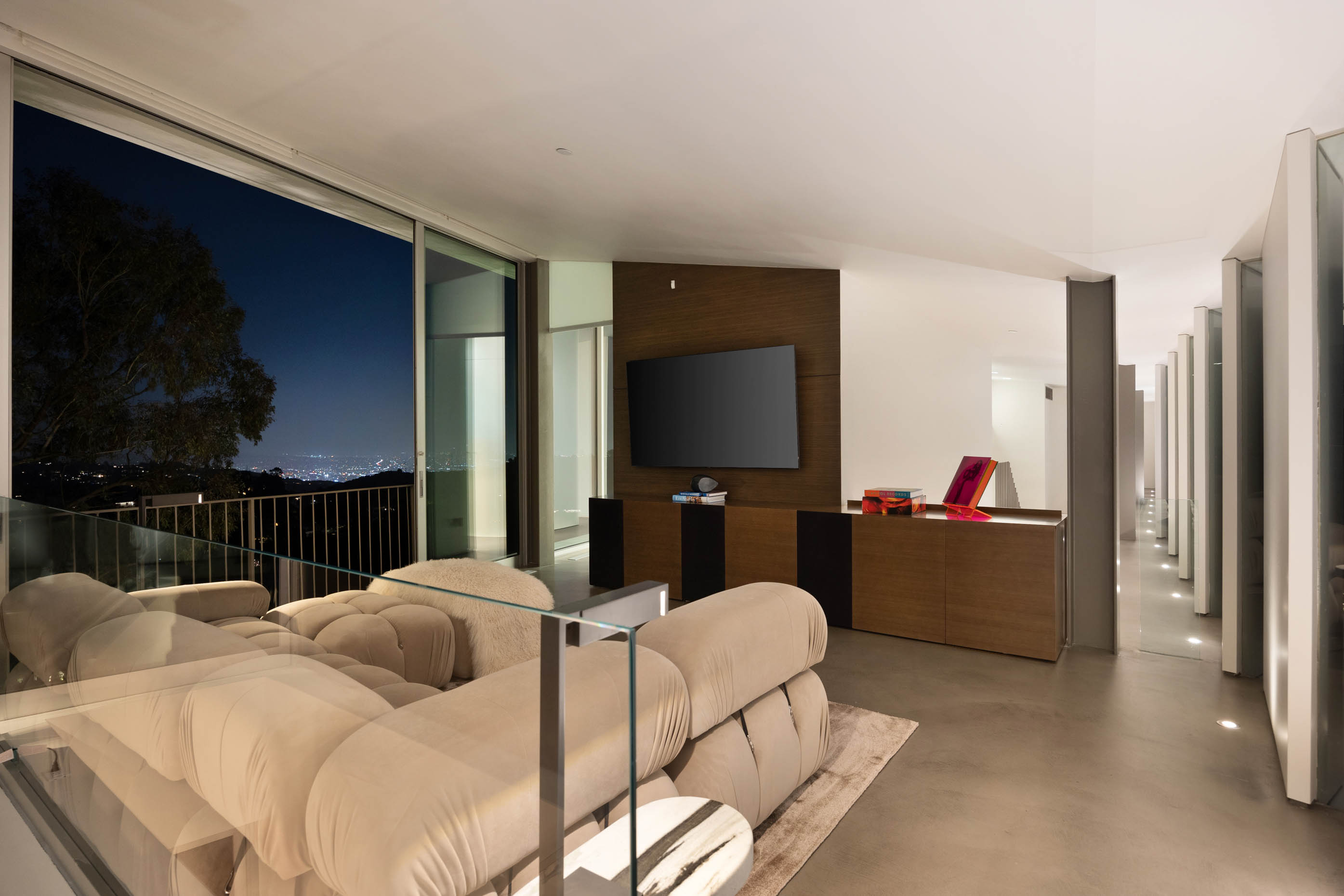 Floor-to-ceiling glass doors provide a captivating view, seamlessly blending indoor elegance with the allure of city lights.