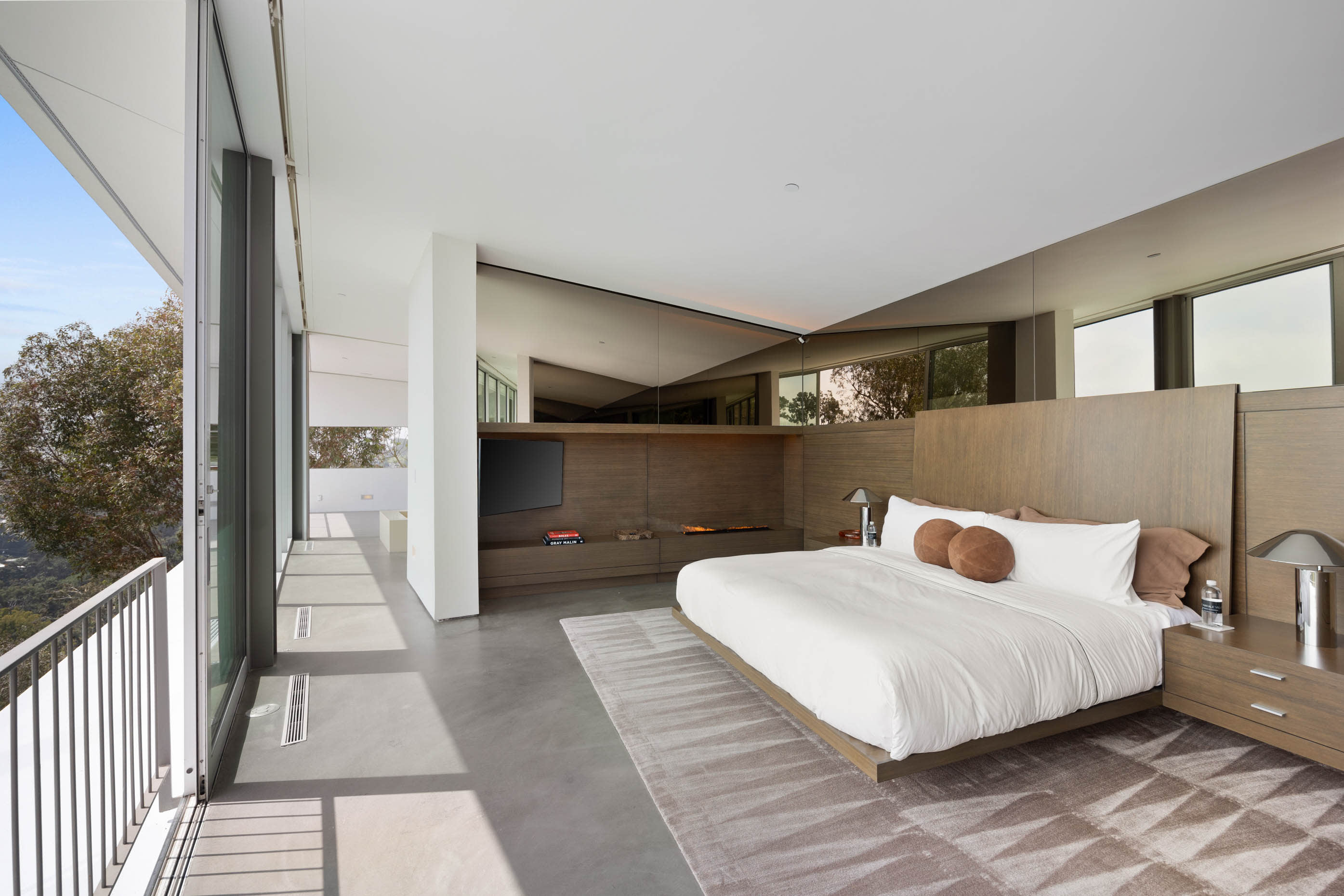 Lavish bedroom with a huge bed and floor-to-ceiling windows, providing spectacular views.
