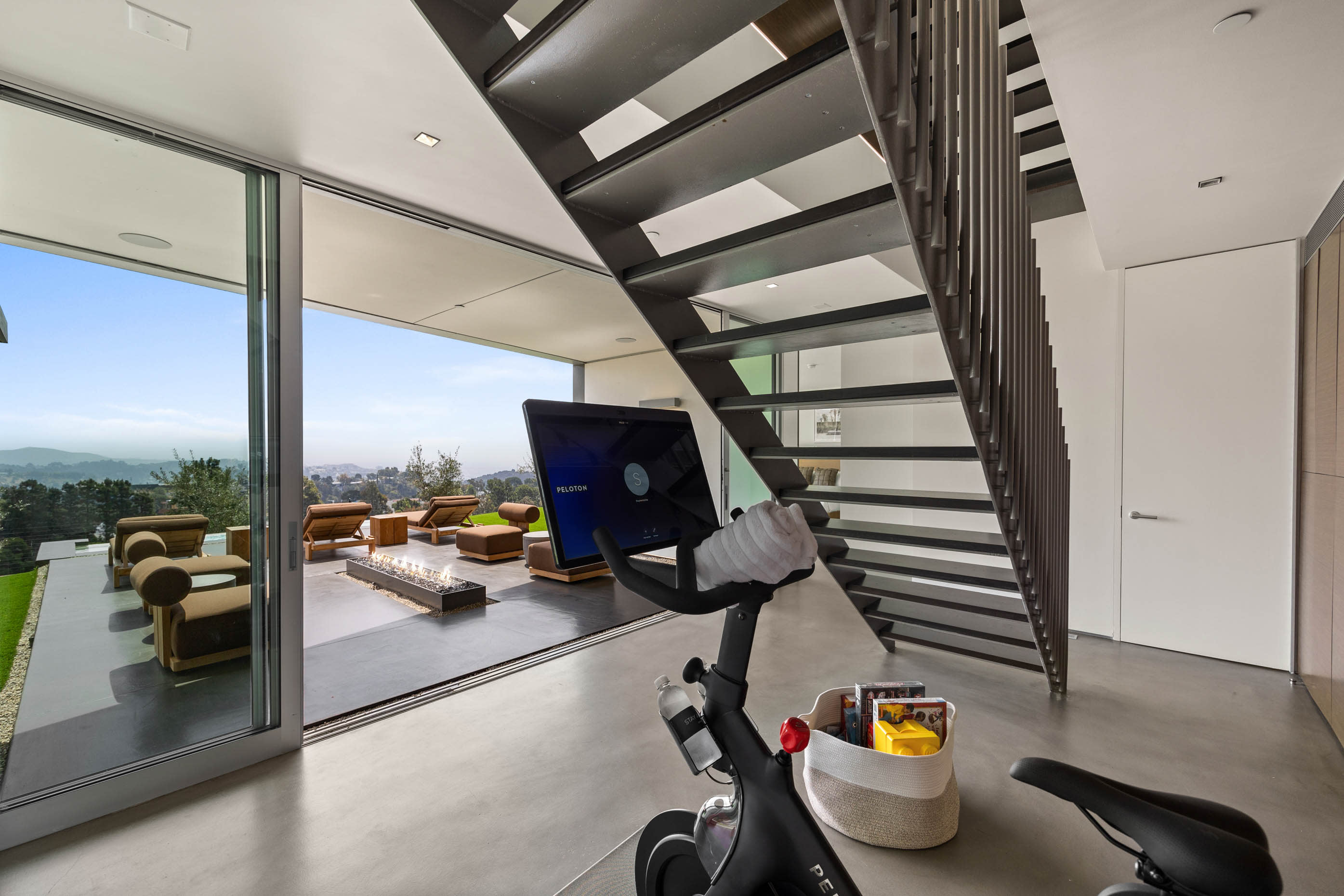 Fitness area equipped with modern workout equipment, offering inspiring views and direct access to the pool.