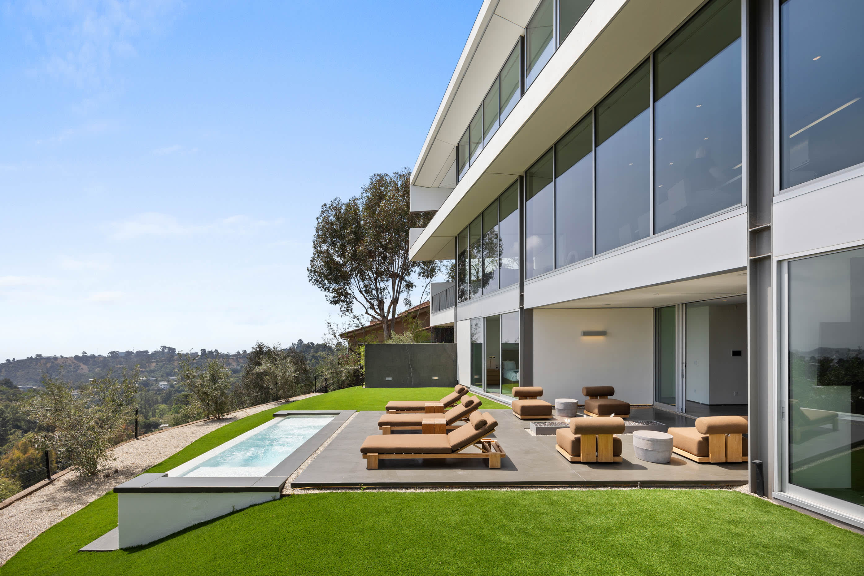 Outdoor oasis featuring a pristine pool and luxurious sunbeds, perfect for soaking up the California sun.