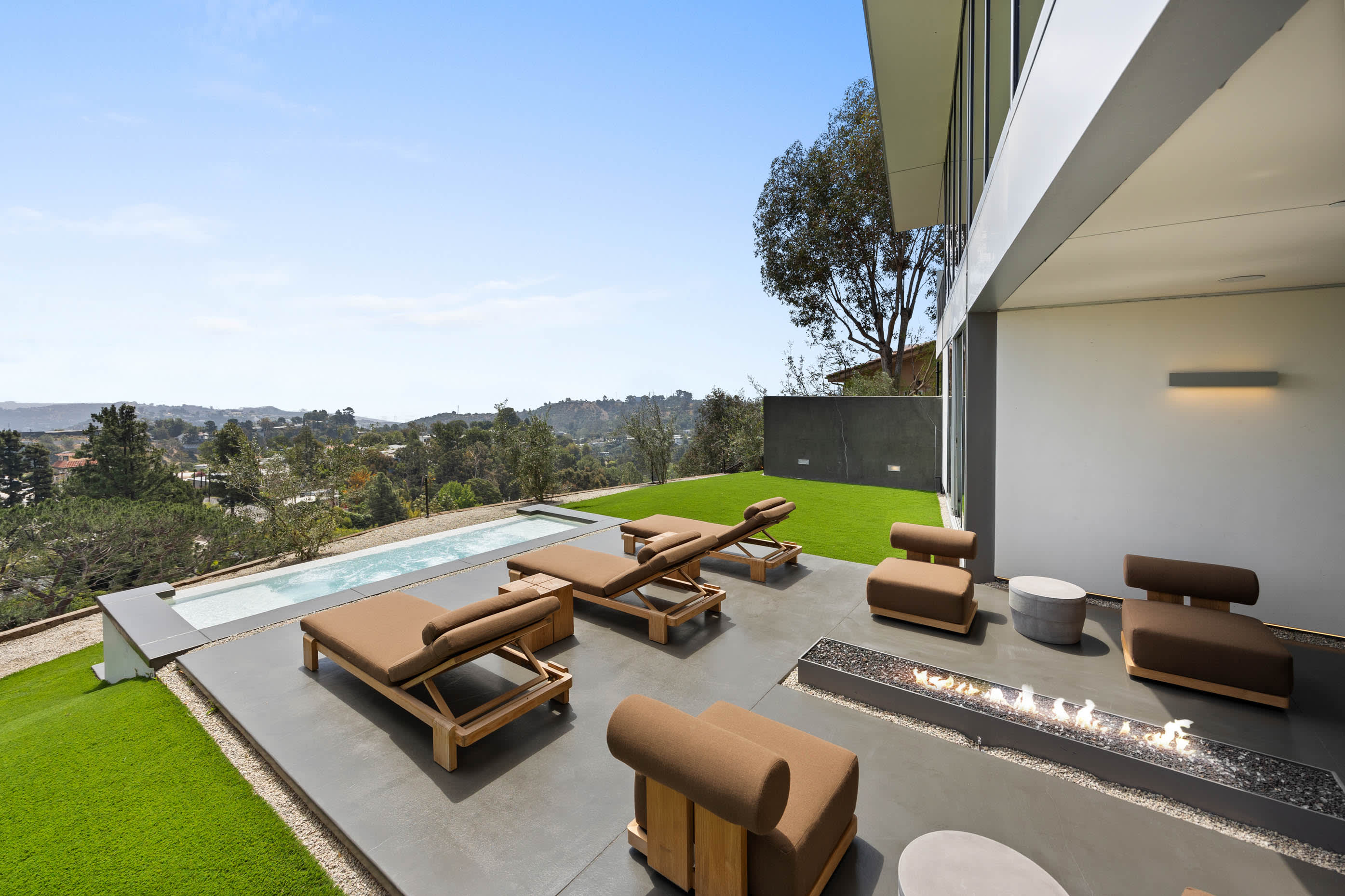 Expansive outdoor haven featuring a pristine pool, an elegant fire pit, and luxurious seating, perfect for refined relaxation.