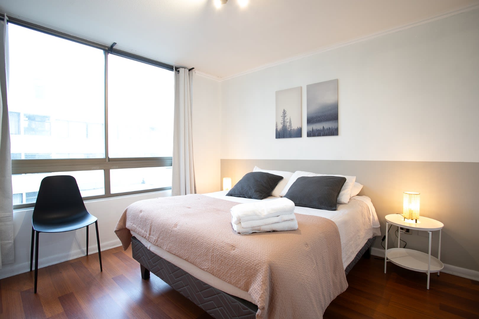 Relax in this cozy bedroom with natural light and modern decor, perfect for a restful night's sleep.