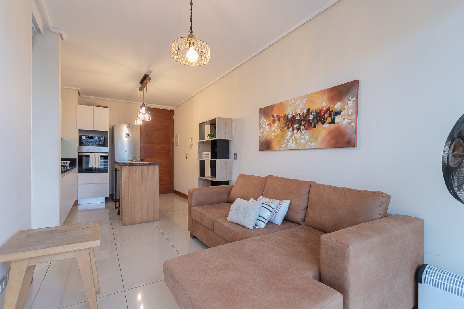 Cozy living area with a stylish kitchen and vibrant artwork, perfect for unwinding after exploring the city.