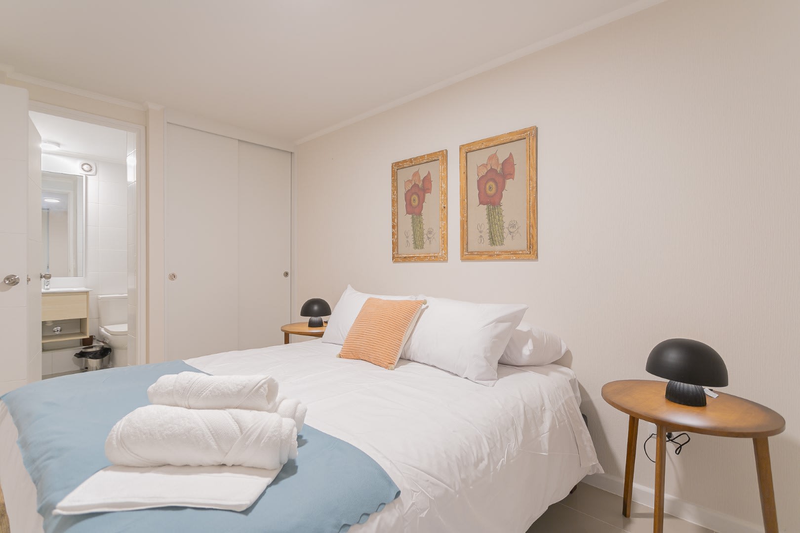 Relax in this inviting bedroom with modern decor and ensuite bathroom, perfect for a restful stay.