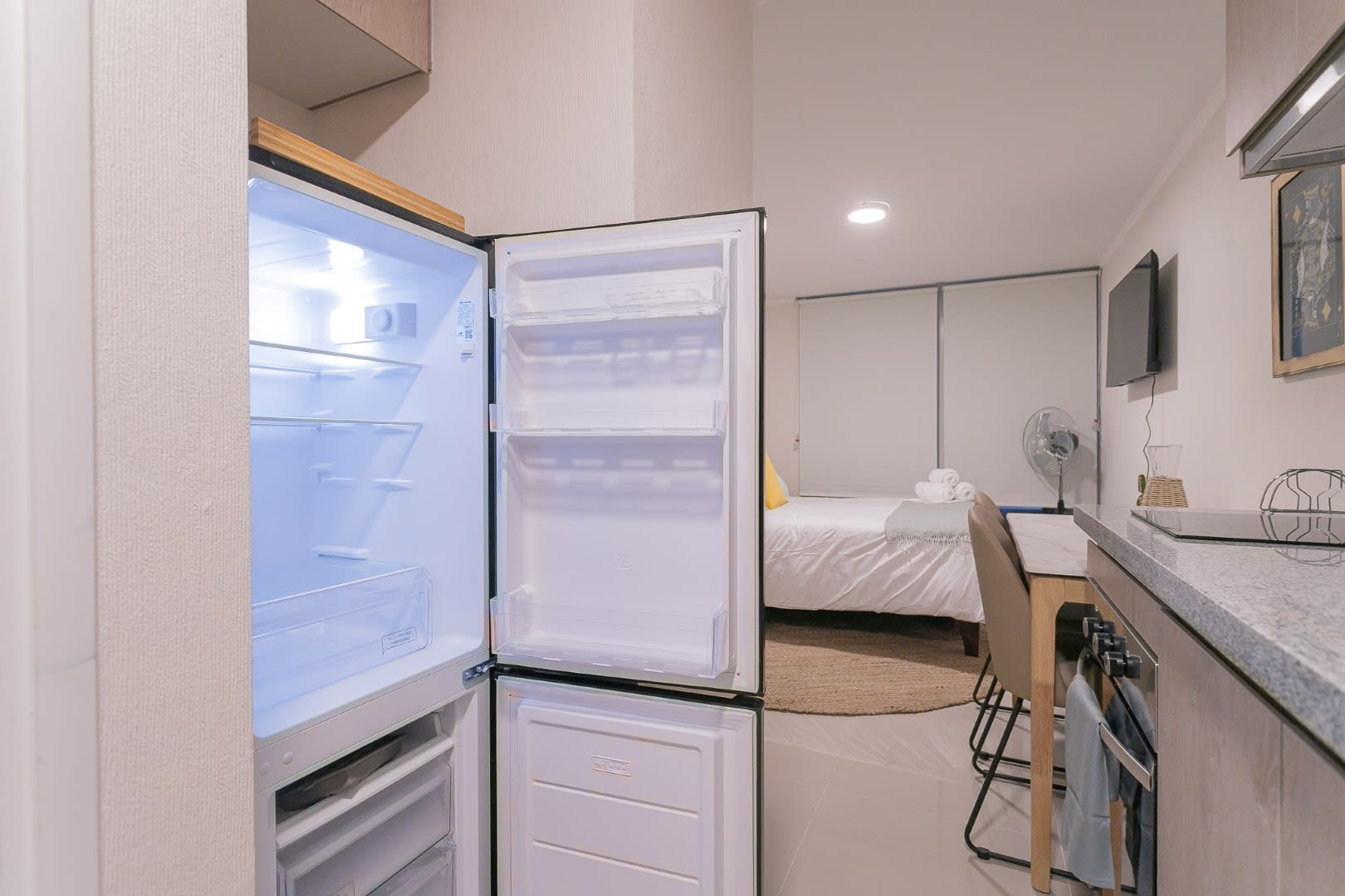 Enjoy a compact and functional kitchen space with modern amenities, perfect for a cozy stay in this stylish studio apartment.