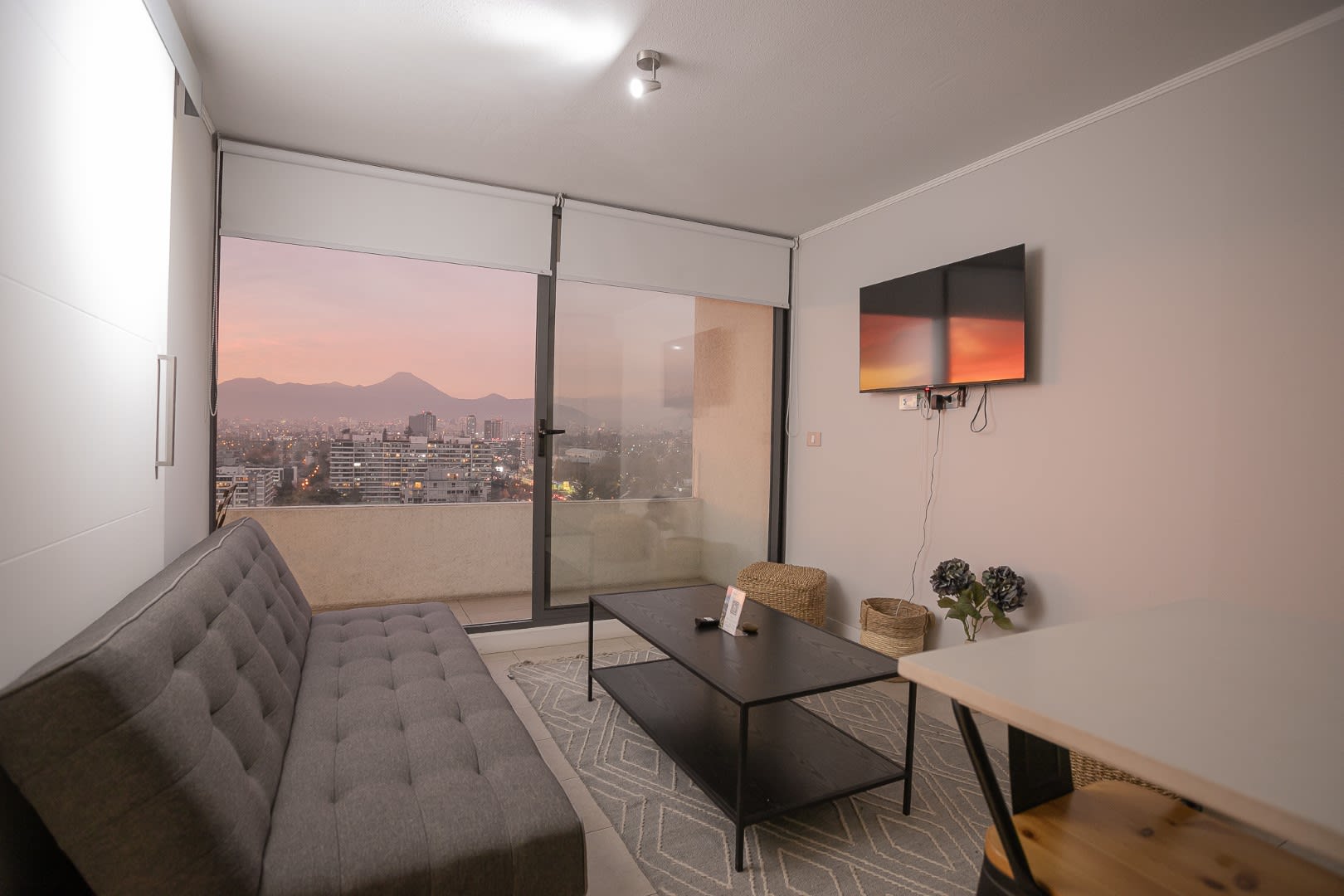 Relax in this cozy living room with breathtaking city views and a stunning sunset backdrop.