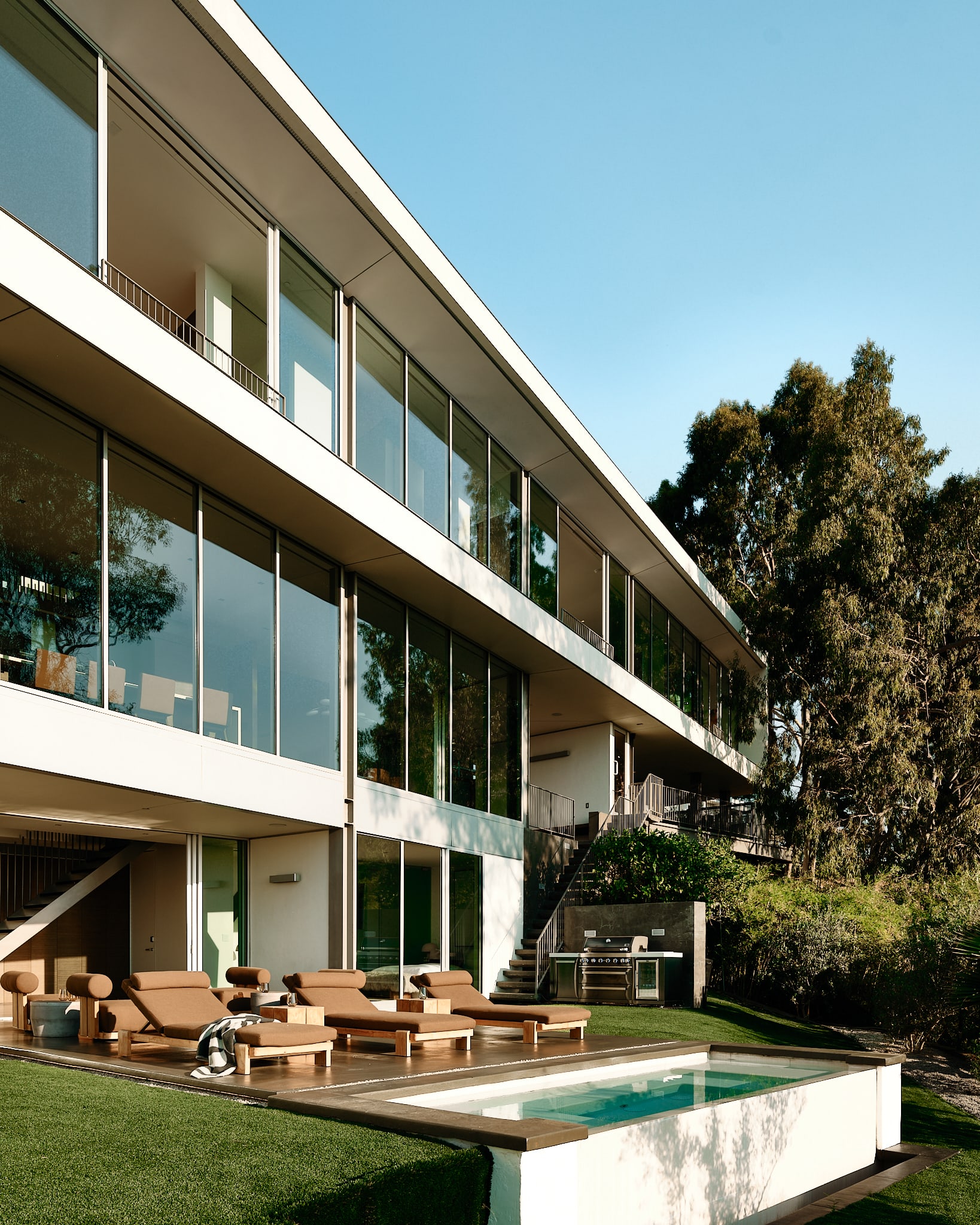 Inviting pool area surrounded by lush landscaping and stylish loungers.