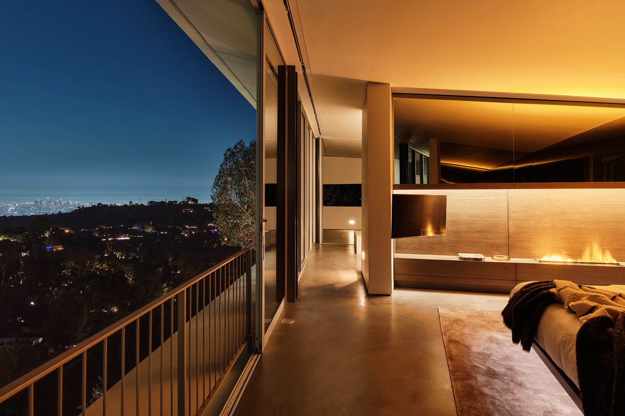 Master bedroom with a sleek linear fireplace and custom RH Modern furnishings.