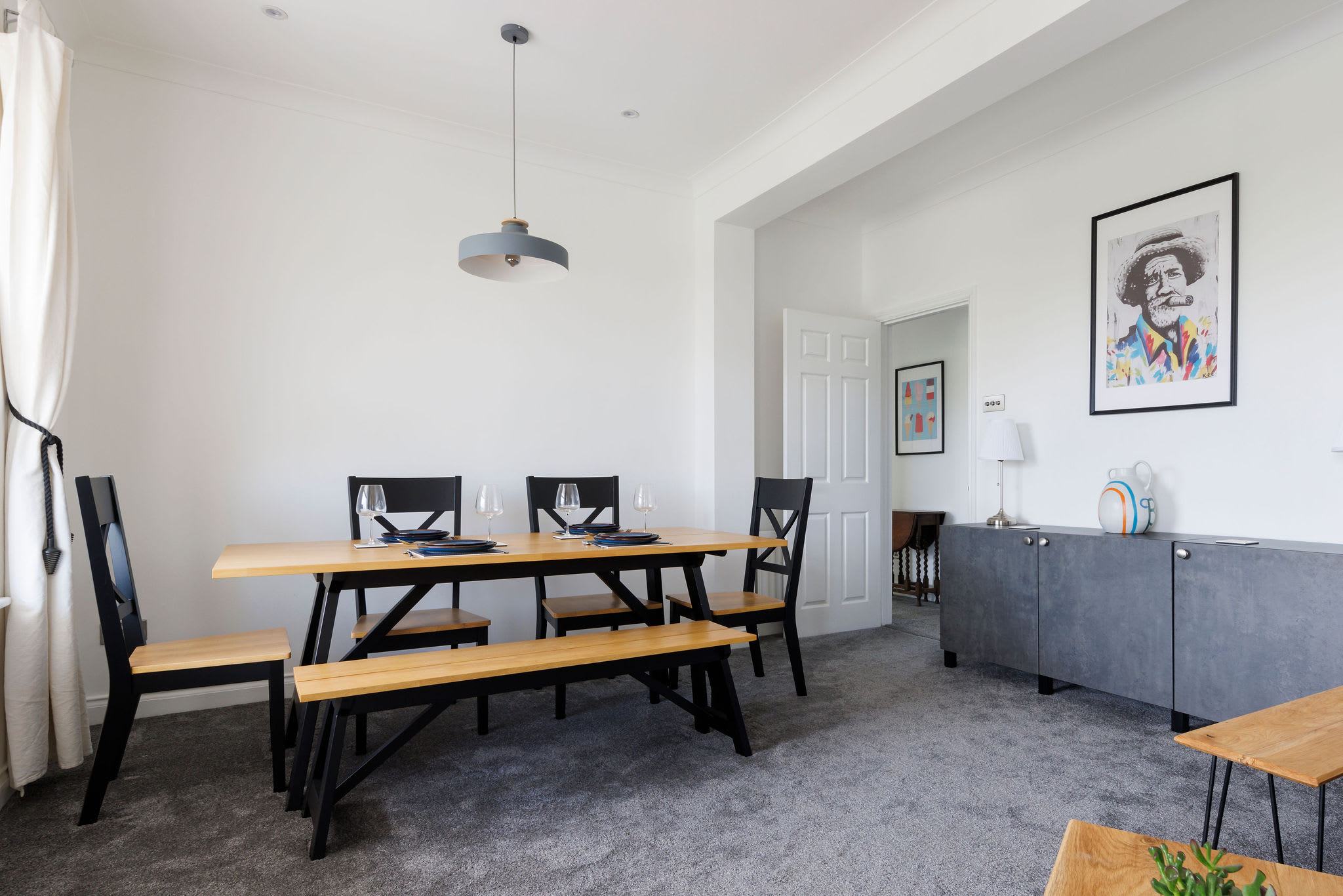 Enjoy meals together in the modern dining area, featuring a sleek table and ample seating.