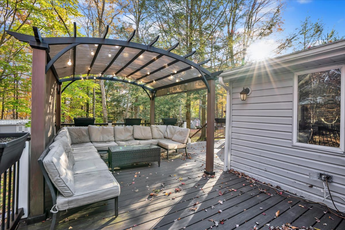 A covered pergola with ample seating offers a perfect outdoor retreat, ideal for unwinding in the fresh air.