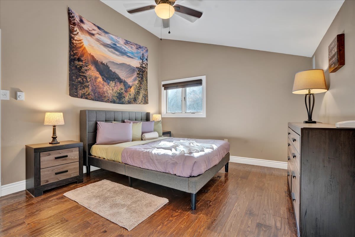 A sleek modern bedframe paired with soft lighting and elegant decor creates a warm, inviting retreat.