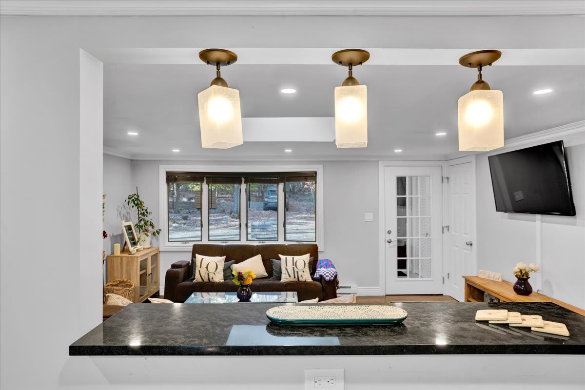 Kitchen Island with a View
Gather around this stylish island, perfect for casual dining, sipping coffee, or enjoying good company. Overhead lighting sets the mood while the open view into the living room keeps the space warm and social.