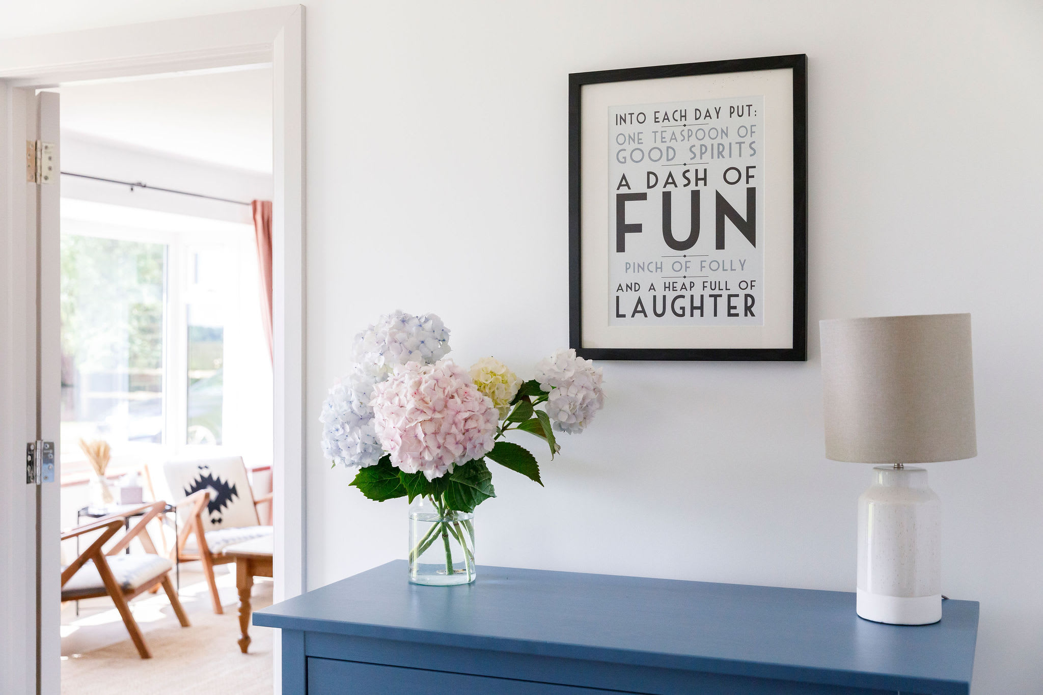 Bright and cheerful entryway with fresh flowers and an uplifting quote