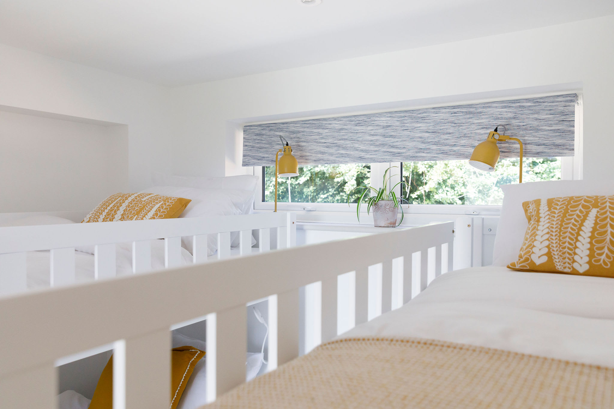Light-filled bunk bed room with comfortable bedding and playful decor